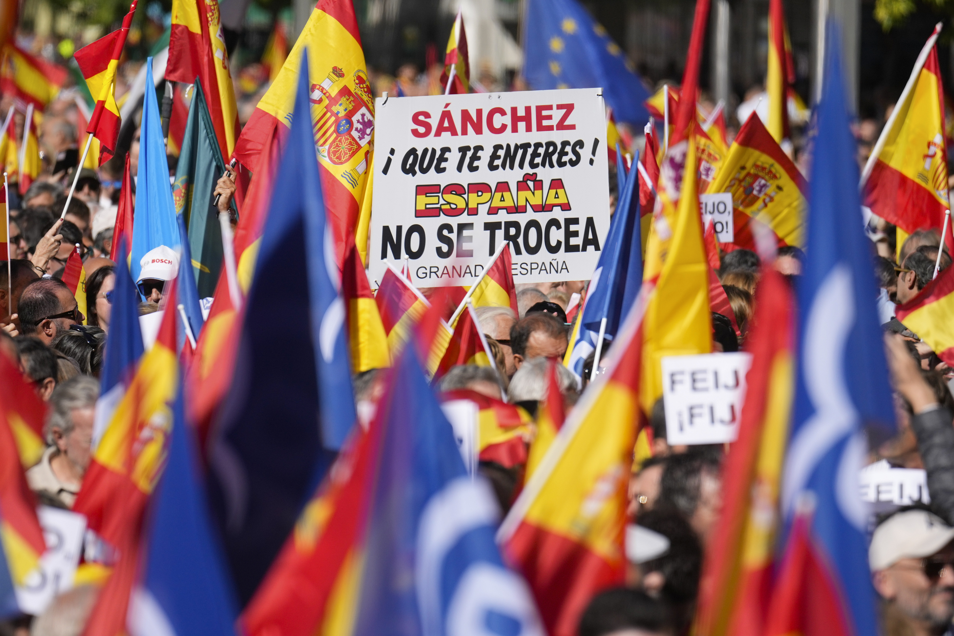 Asistentes al acto de PP muestran un cartel contra Pedro Sánchez.