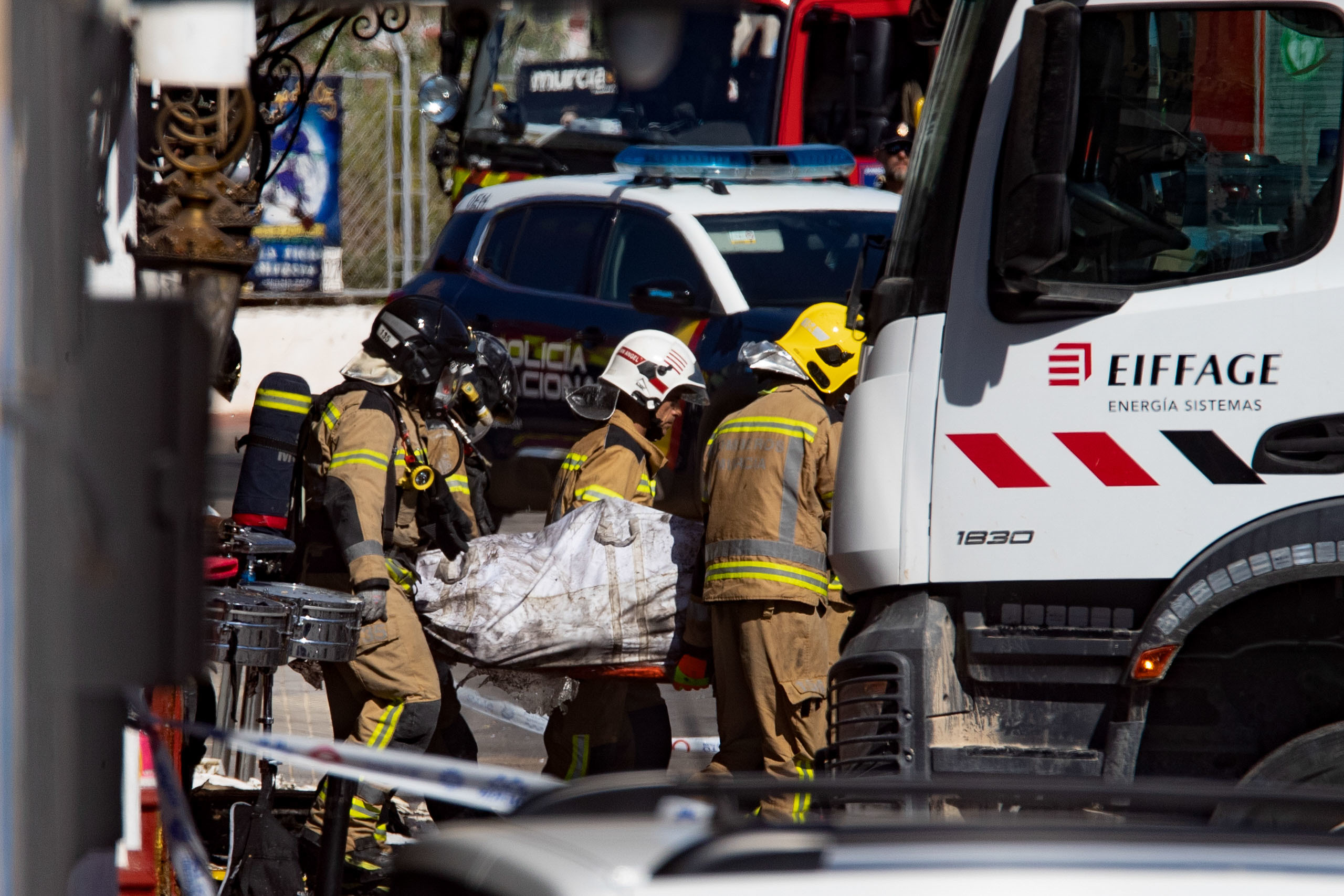 Los servicios de emergencia trasladan a una persona fallecida en el incendio de Murcia.