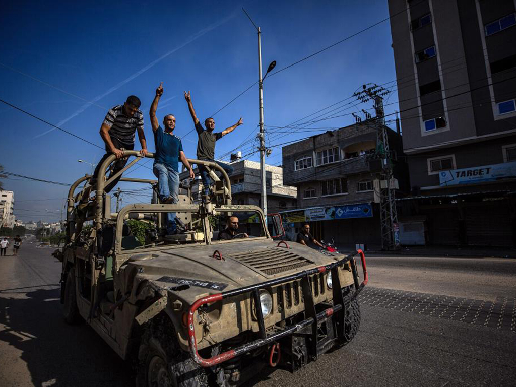 Palestinos montan en un jeep militar israel