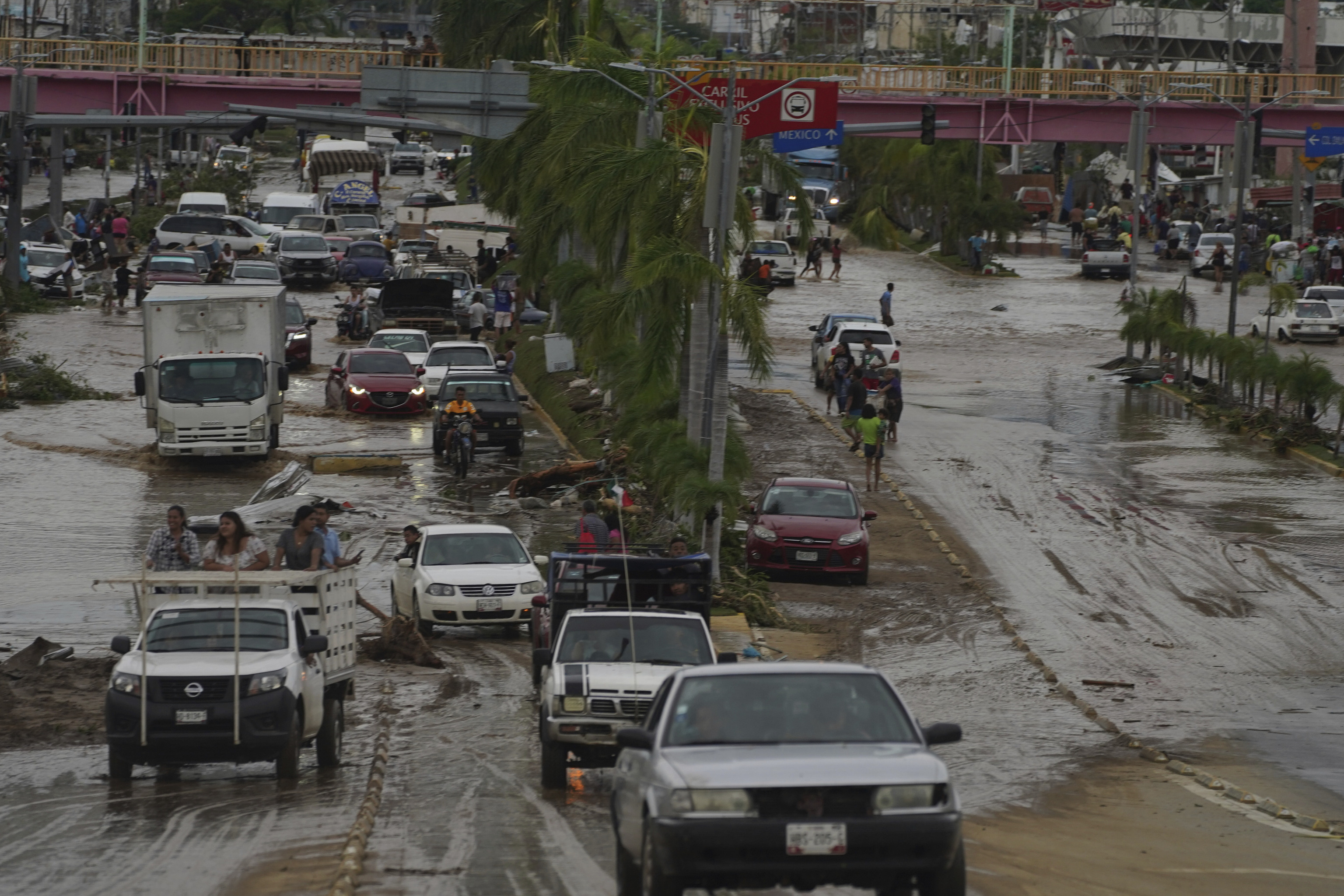Autos cruzan una avenida anegada tras el paso del hurac