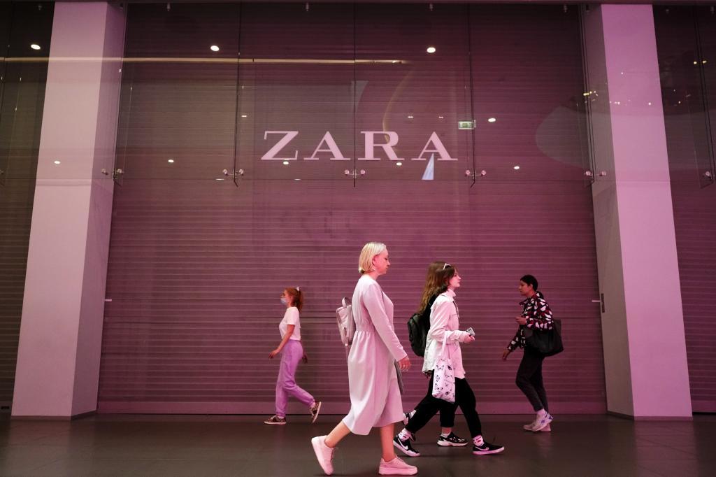 Personas caminando frente a una tienda de Zara.