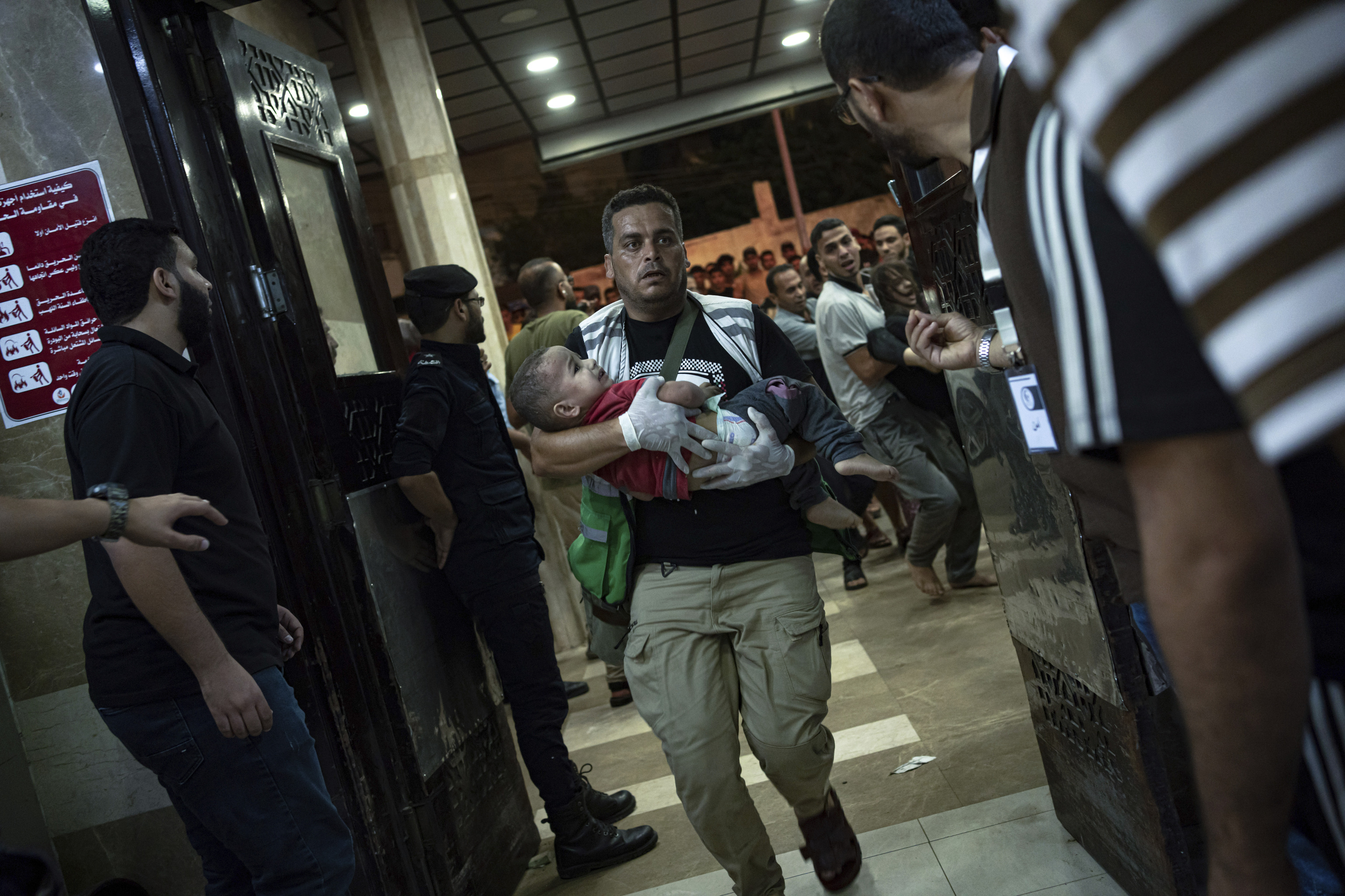 Un hombre lleva en brazos a un nio a  un hospital en Gaza.