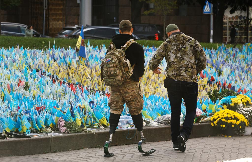 Un soldado con las piernas amputadas pasa ante las banderas colocadas en la Plaza de la Independencia, en Kiev, en homenaje a los soldados ucranianos ca