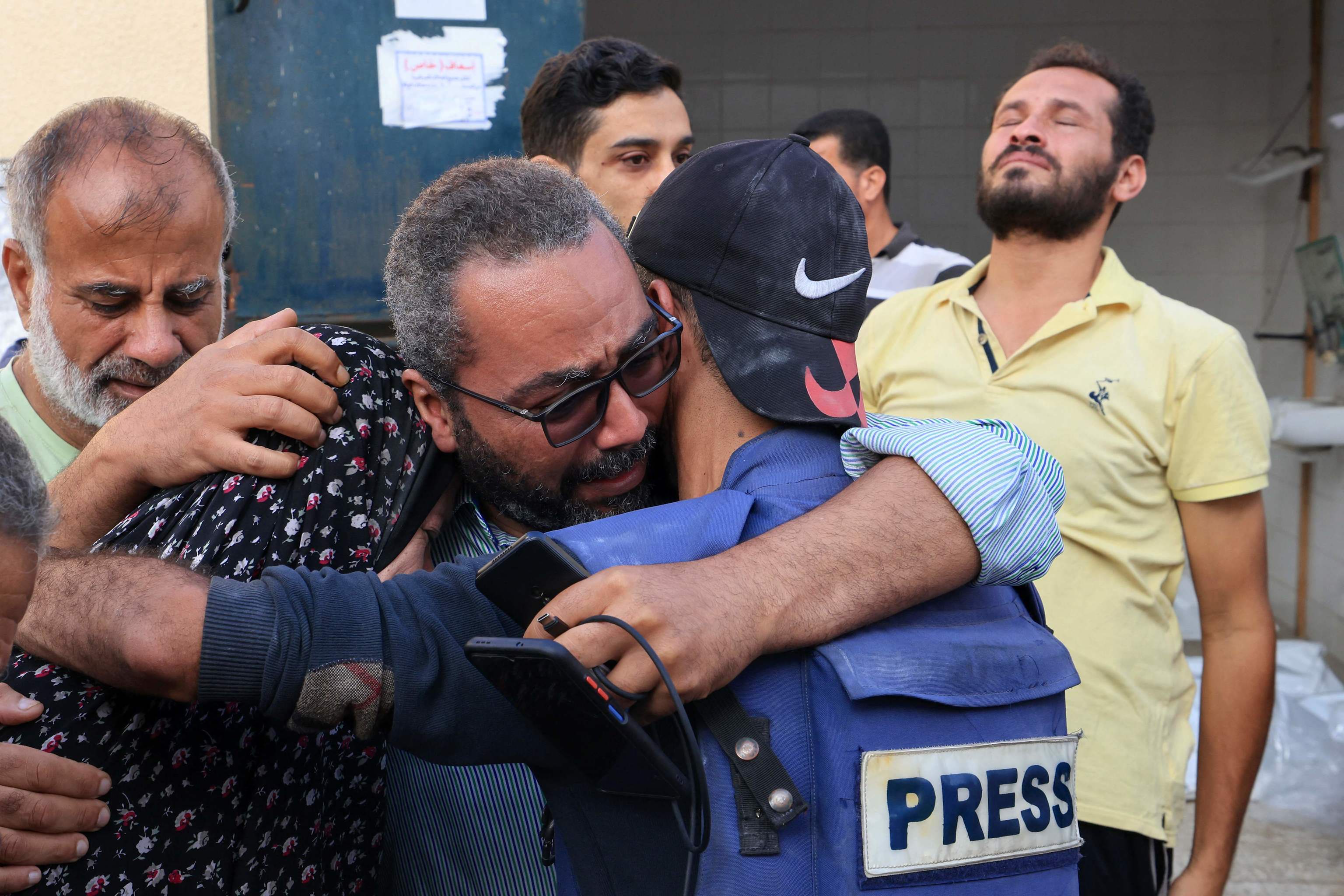 Familiares y amigos del cámara palestino Mohammed Alaloul intentan consolarlo.