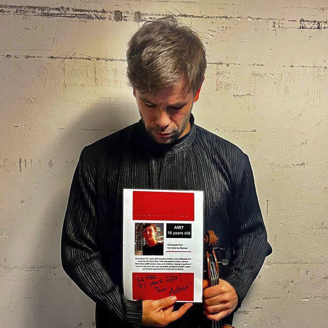Violinista posa con la imagen de su sobrino secuestrado en Gaza.