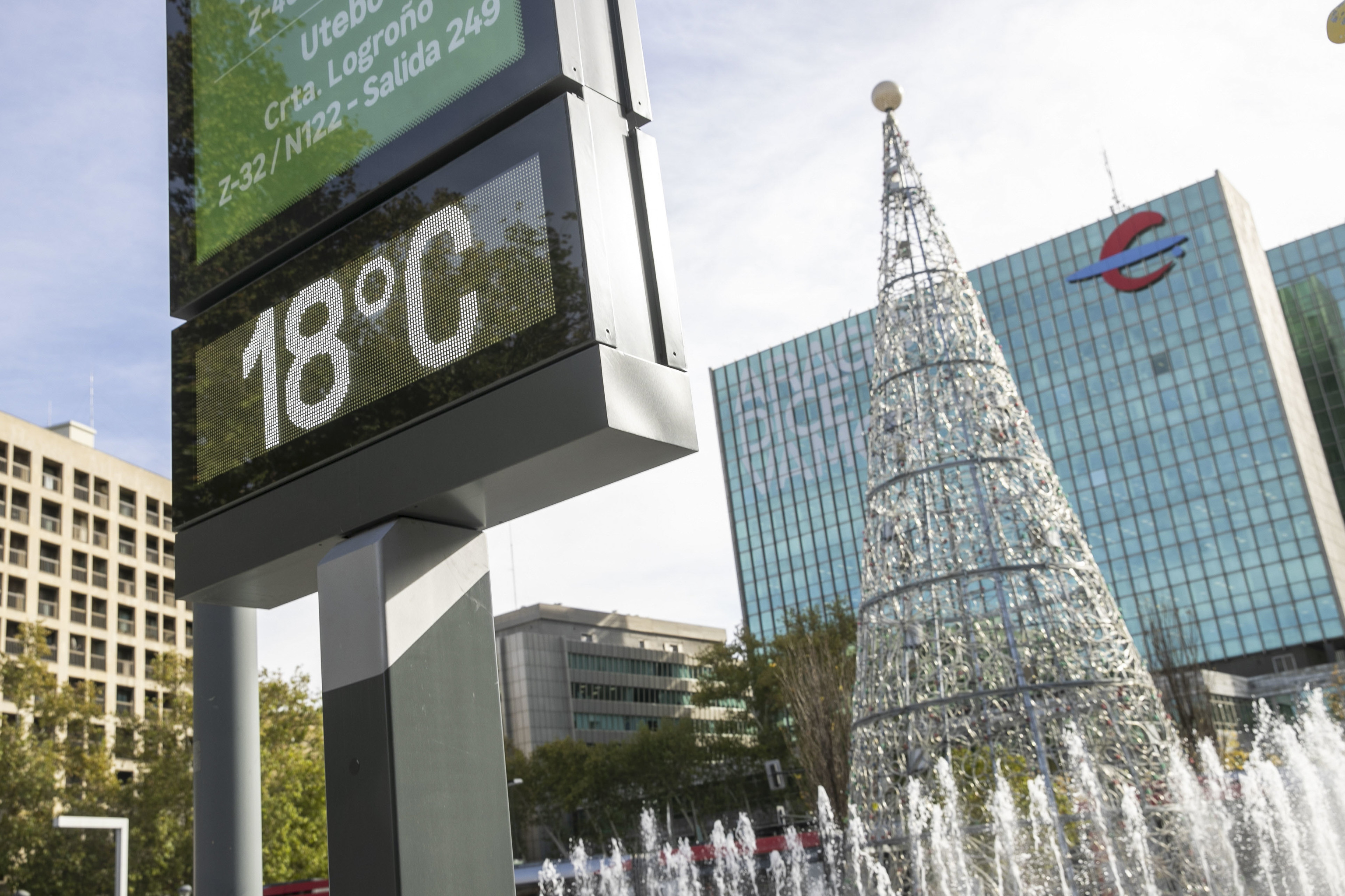 Un termmetro marca 18 grados ante un rbol de navidad en una plaza de Zaragoza.