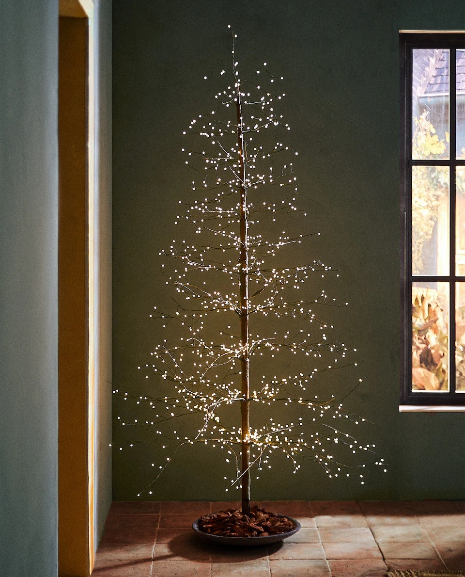 Un árbol de Navidad plegable y otros con luces led de Zara Home que crean tendencia.