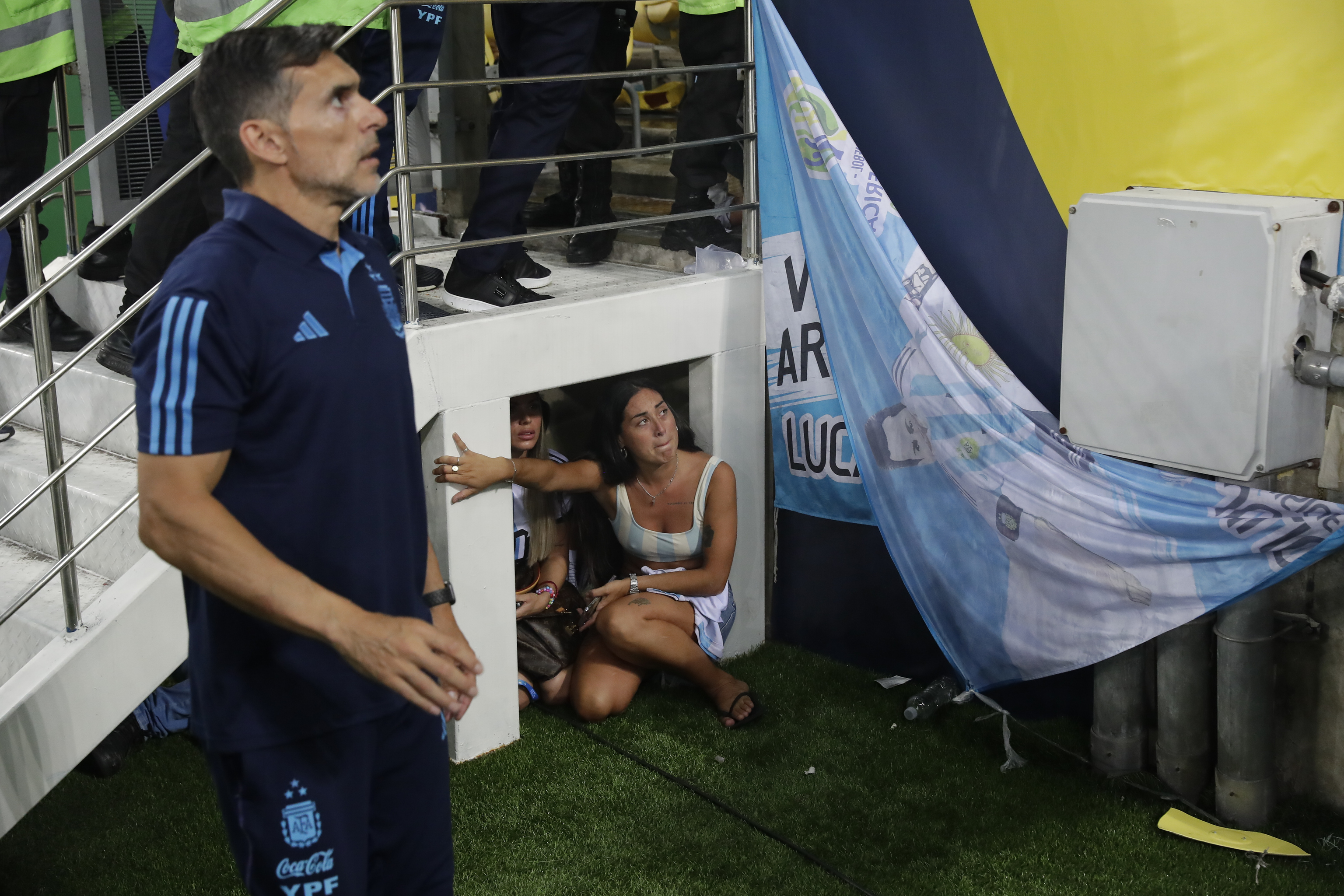 Aficionados argentinos escondidos bajo una escalera.