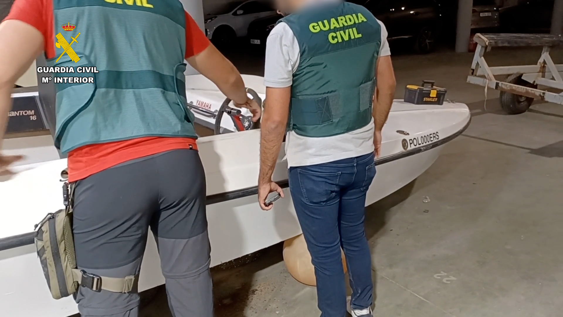 Dos guardias civiles, ante una embarcacin incautada.