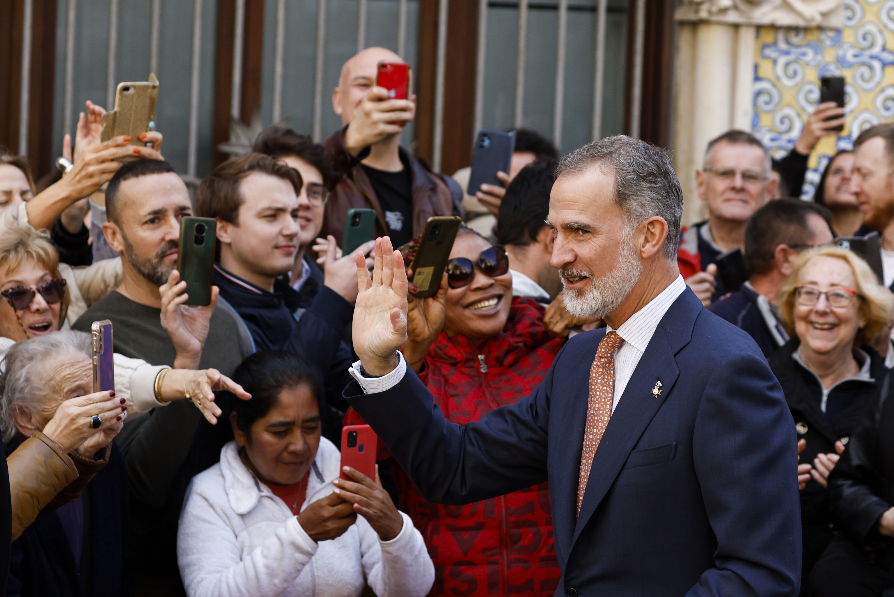 Felipe VI saluda a la gente a su salida de la Lonja de Valencia.