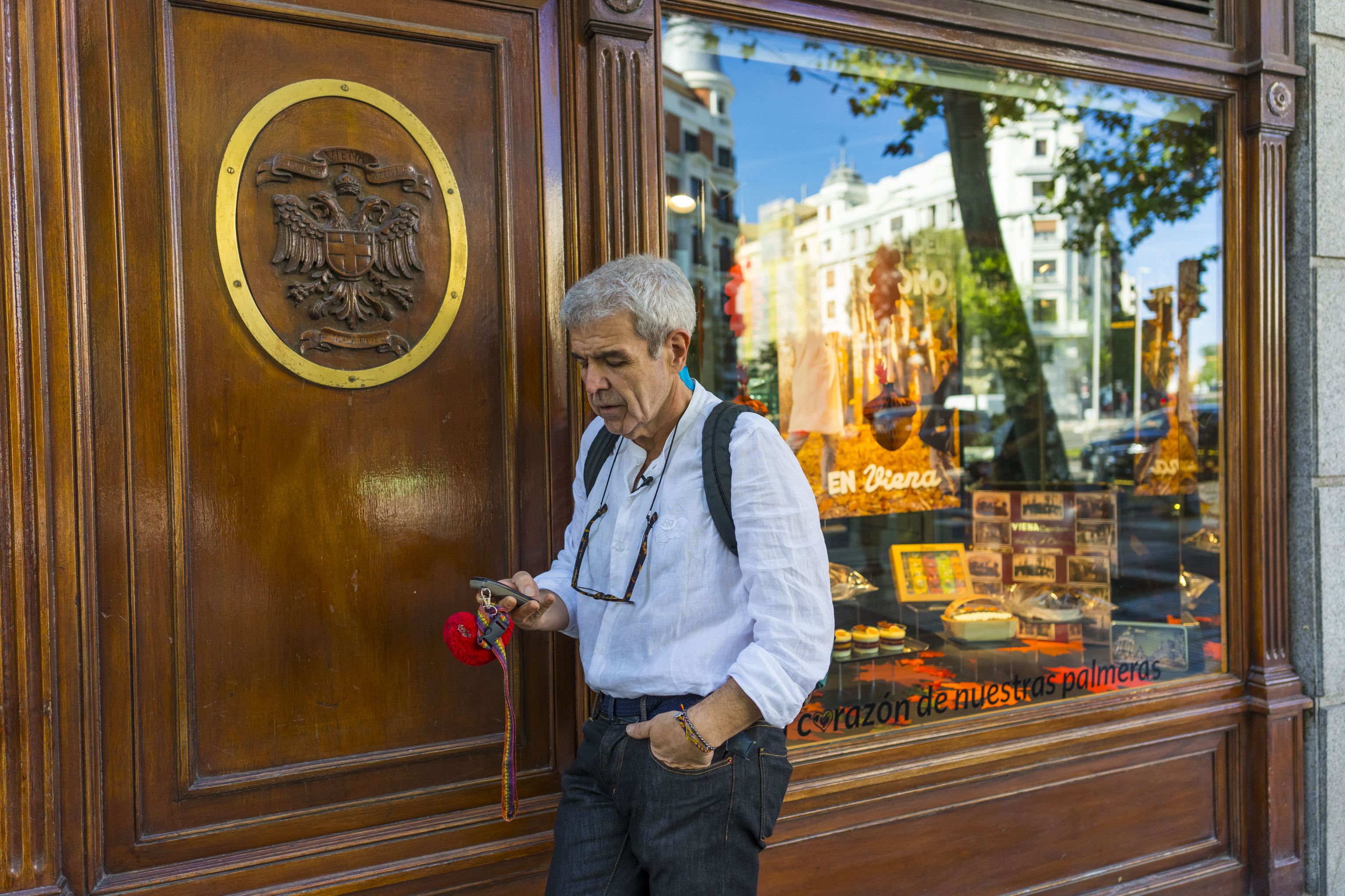 El modista, frente al Viena Capellanes de la calle Génova. Reflejado en el escaparate, uno de los dos hoteles donde ha vivido.