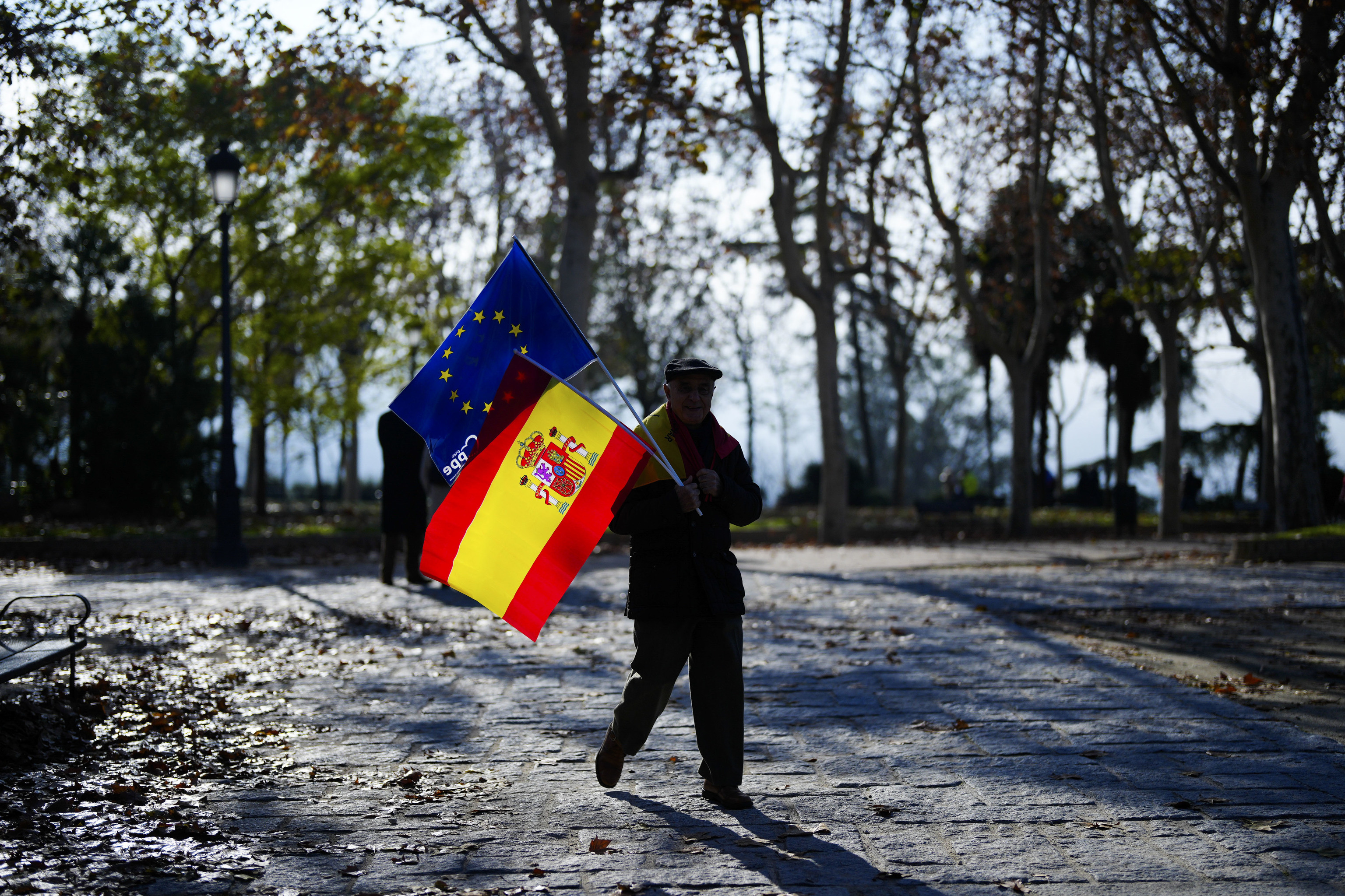 Un hombre con una bandera española y otra europea en el acto del PP en defensa de la Constitución, en Madrid.