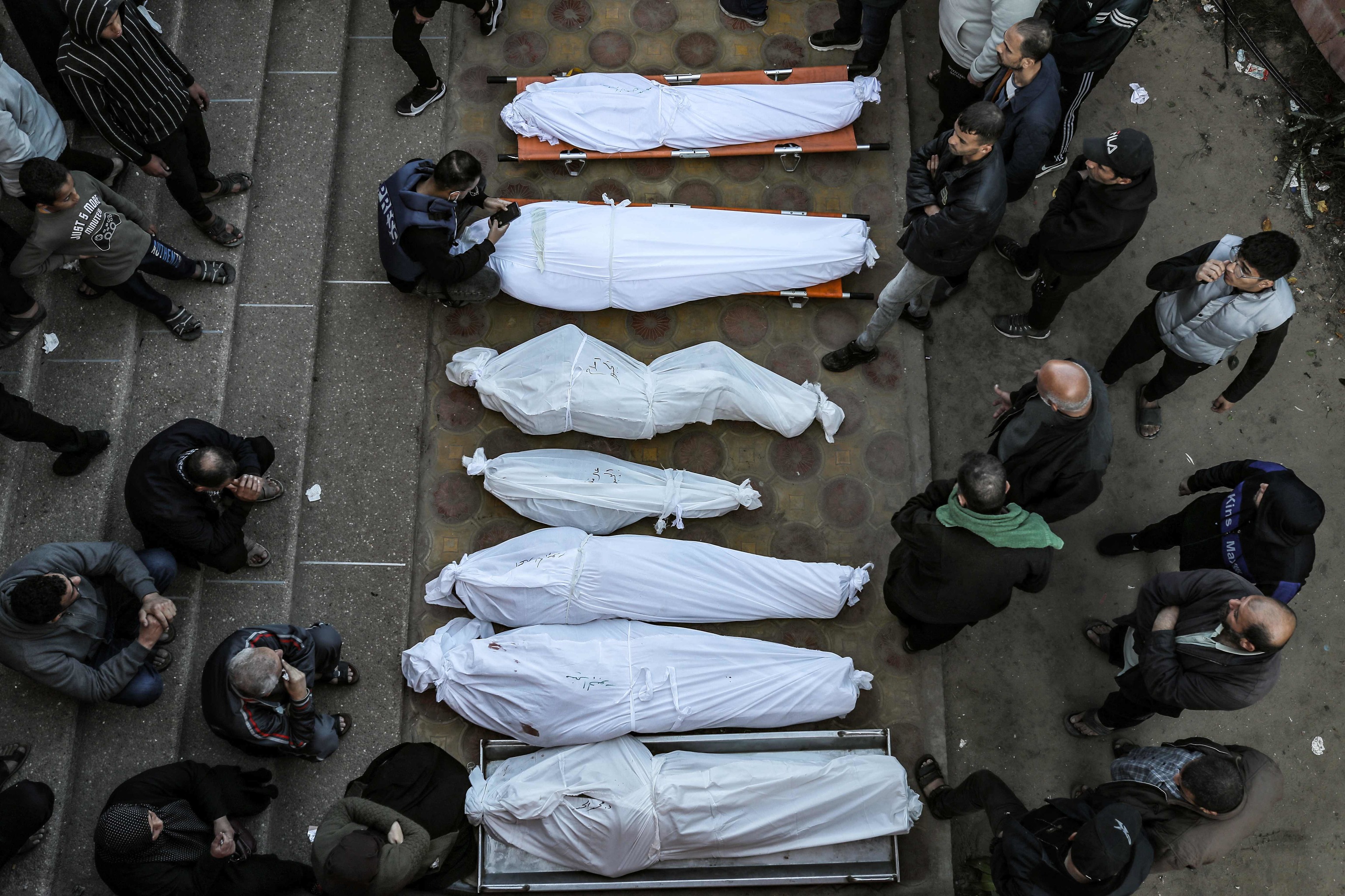 Dolientes junto a los cuerpos amortajados de familiares muertos tras los ataques israelíes, en el hospital Nasser de Khan Yunis, en el sur de la Franja de Gaza, el 9 de diciembre de 2023, en medio de los continuos combates entre Israel y el grupo militante palestino Hamas.