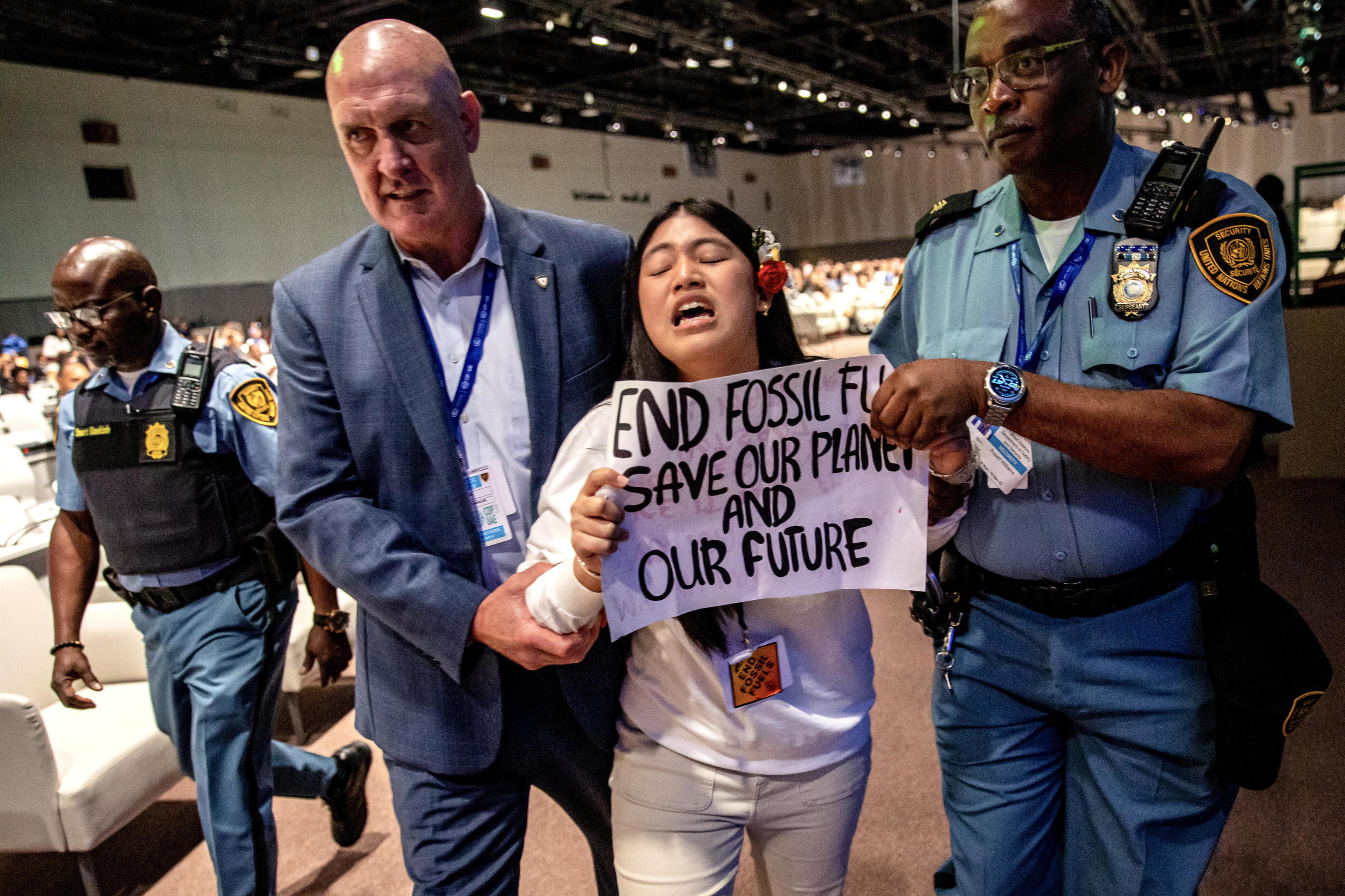 Dos miembros del equipo de seguridad desaloja a una activista india en la COP28