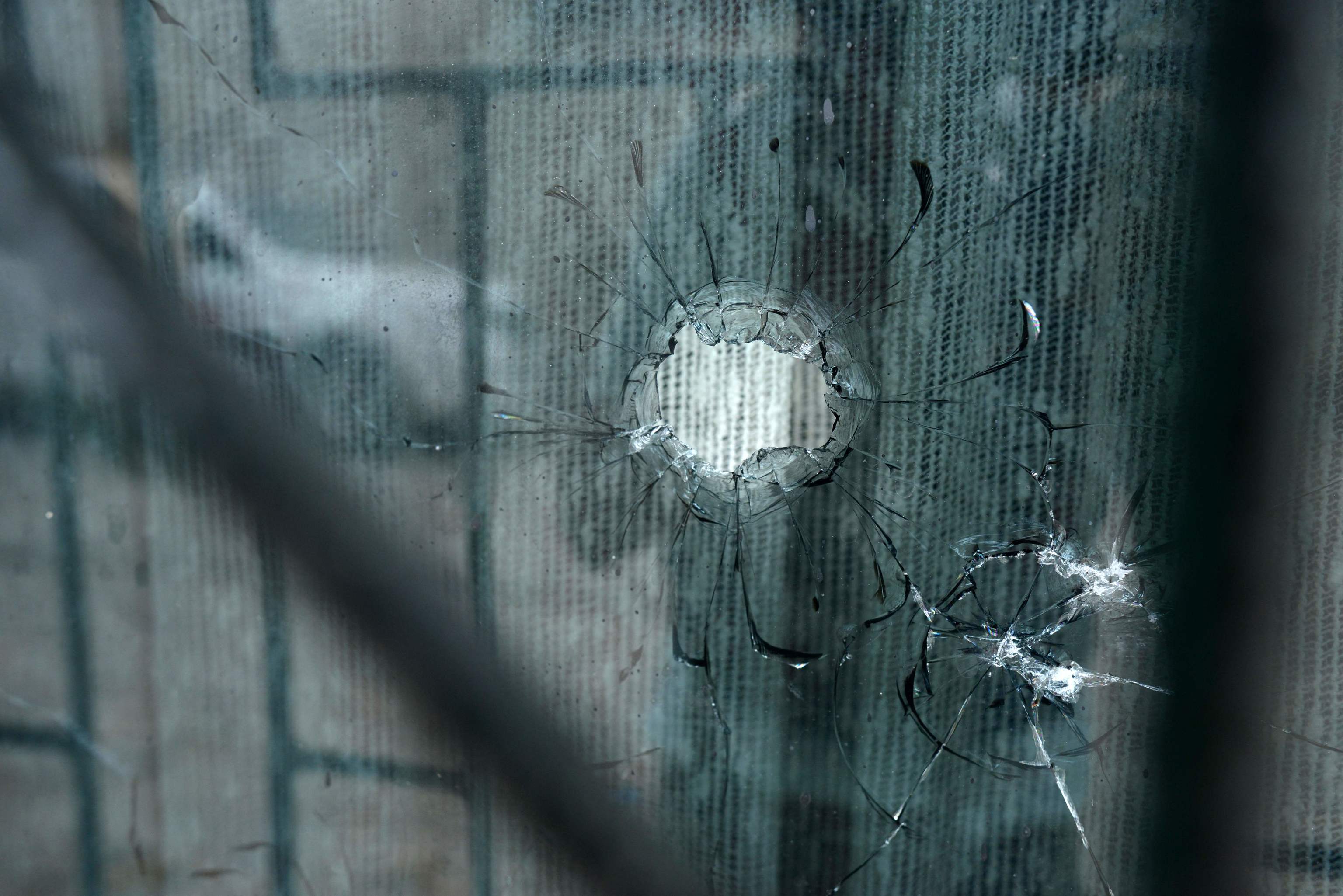Se observa un agujero de bala en la ventana de una casa donde pistoleros mataron a cuatro ni