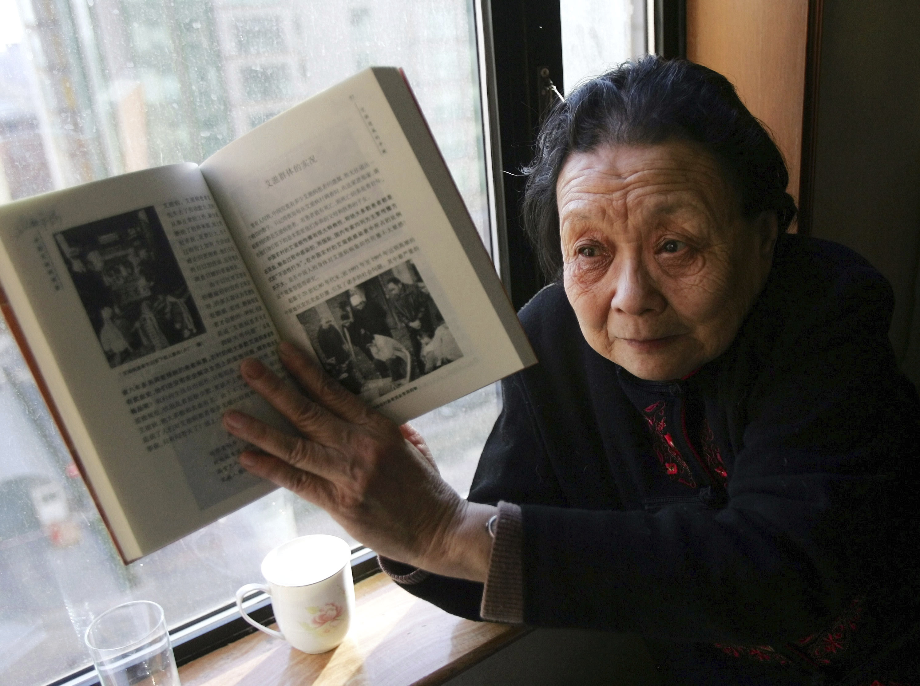 La activista contra el sida Gao Yaojie muestra un libro que escribi