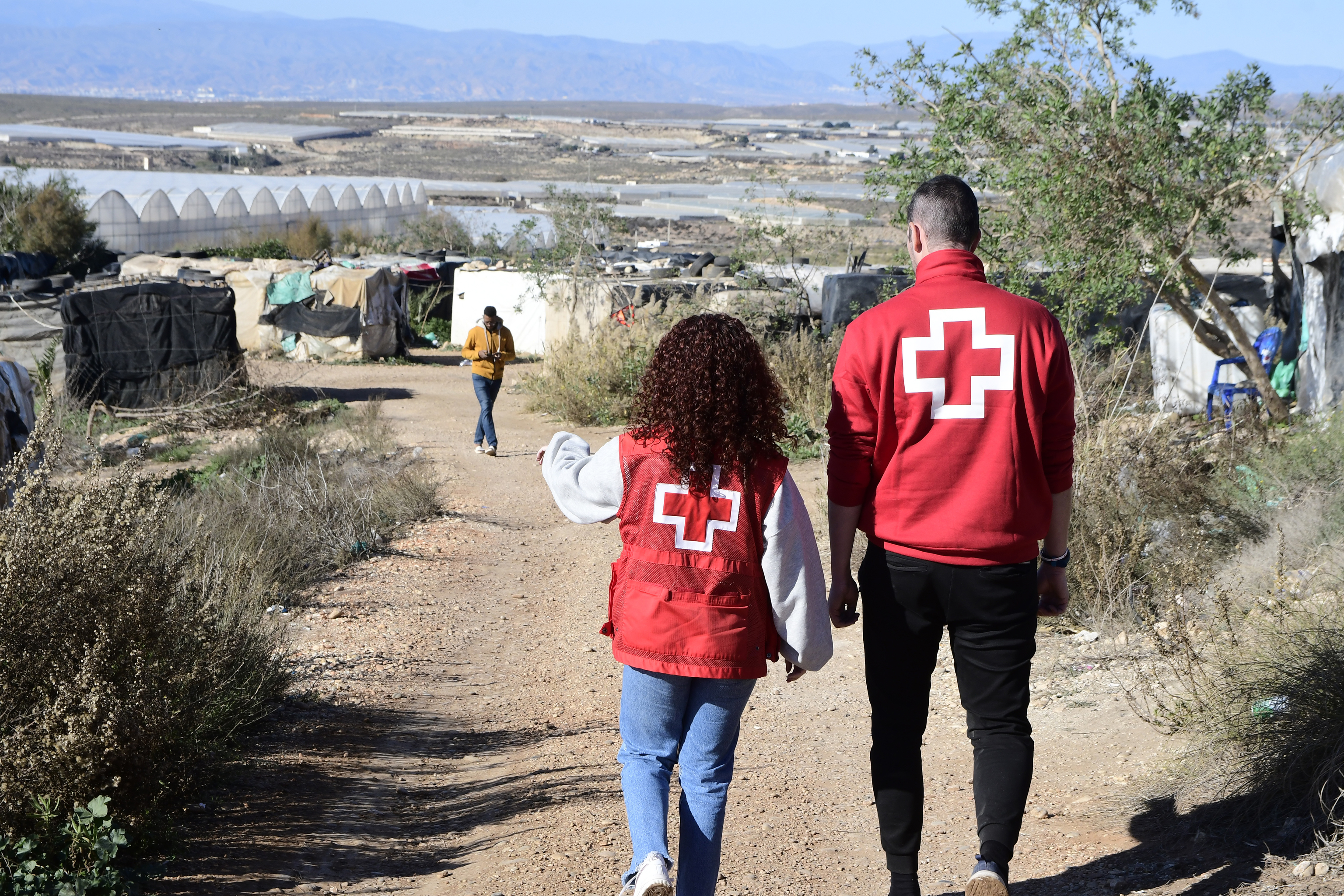 Dos trabajadores de Cruz Roja, este sábado, en el asentamiento de El Hoyo.