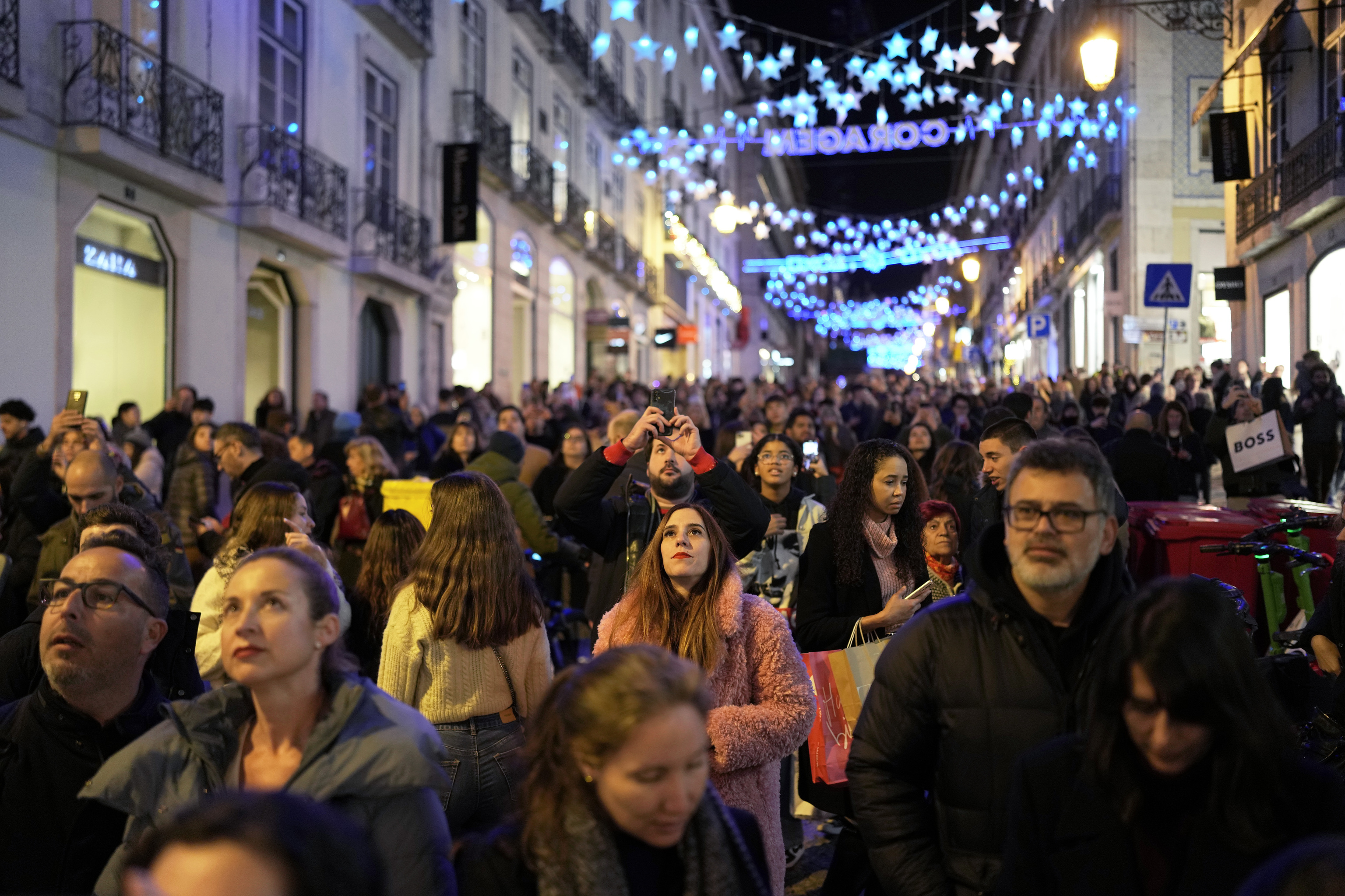 Las personas miran las luces de Navidad mientras las multitudes pasean por el barrio de Chiado en el centro de Lisboa, la tarde del sbado 23 de diciembre de 2023. (Foto de AP/Armando Franca)
