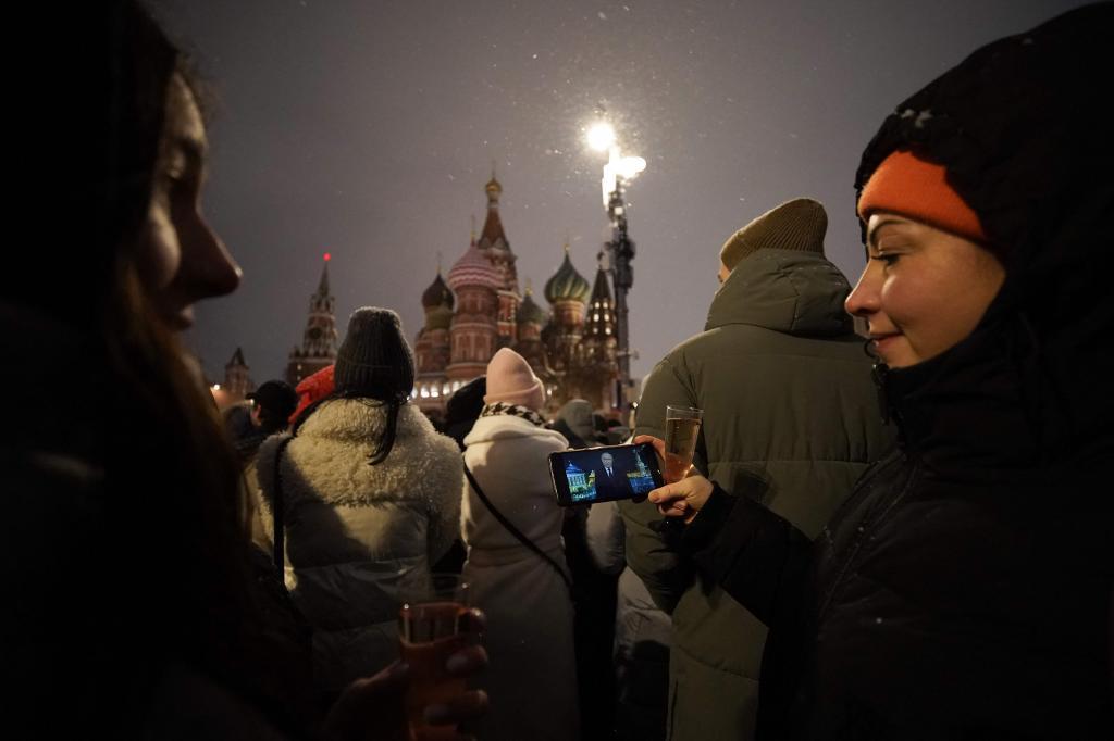 Una mujer sigue el mensaje de Putin a travs del telfono desde la Plaza Roja.