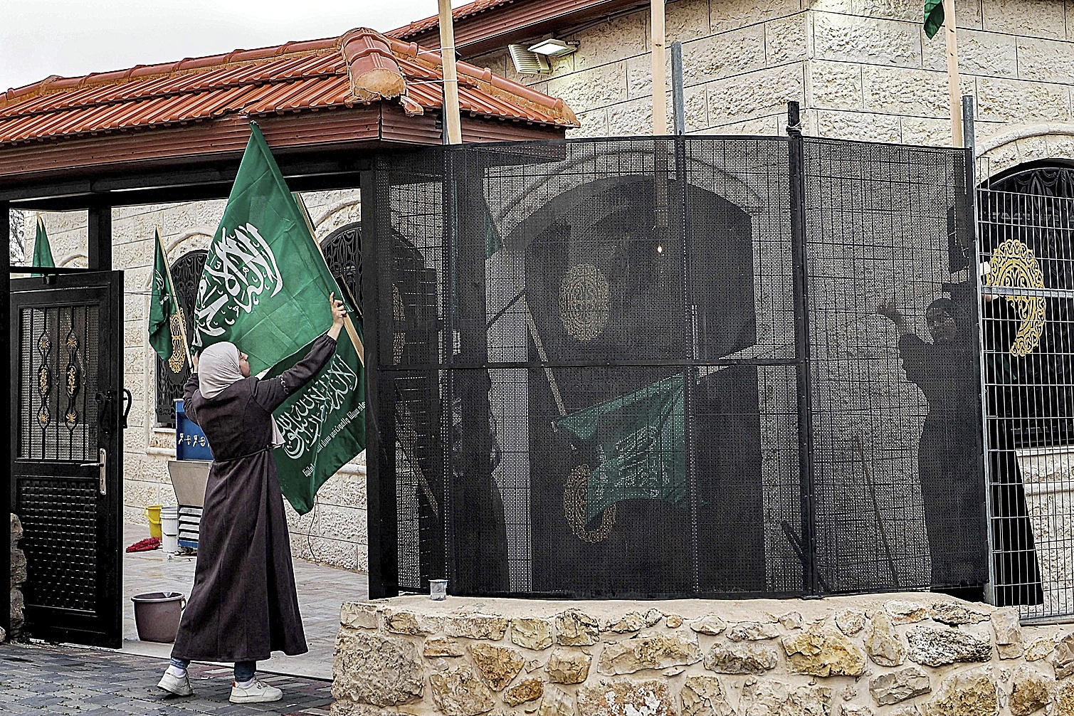 Familiares de Saleh al Arouri cuelgan banderas de Hamas en Ramala.