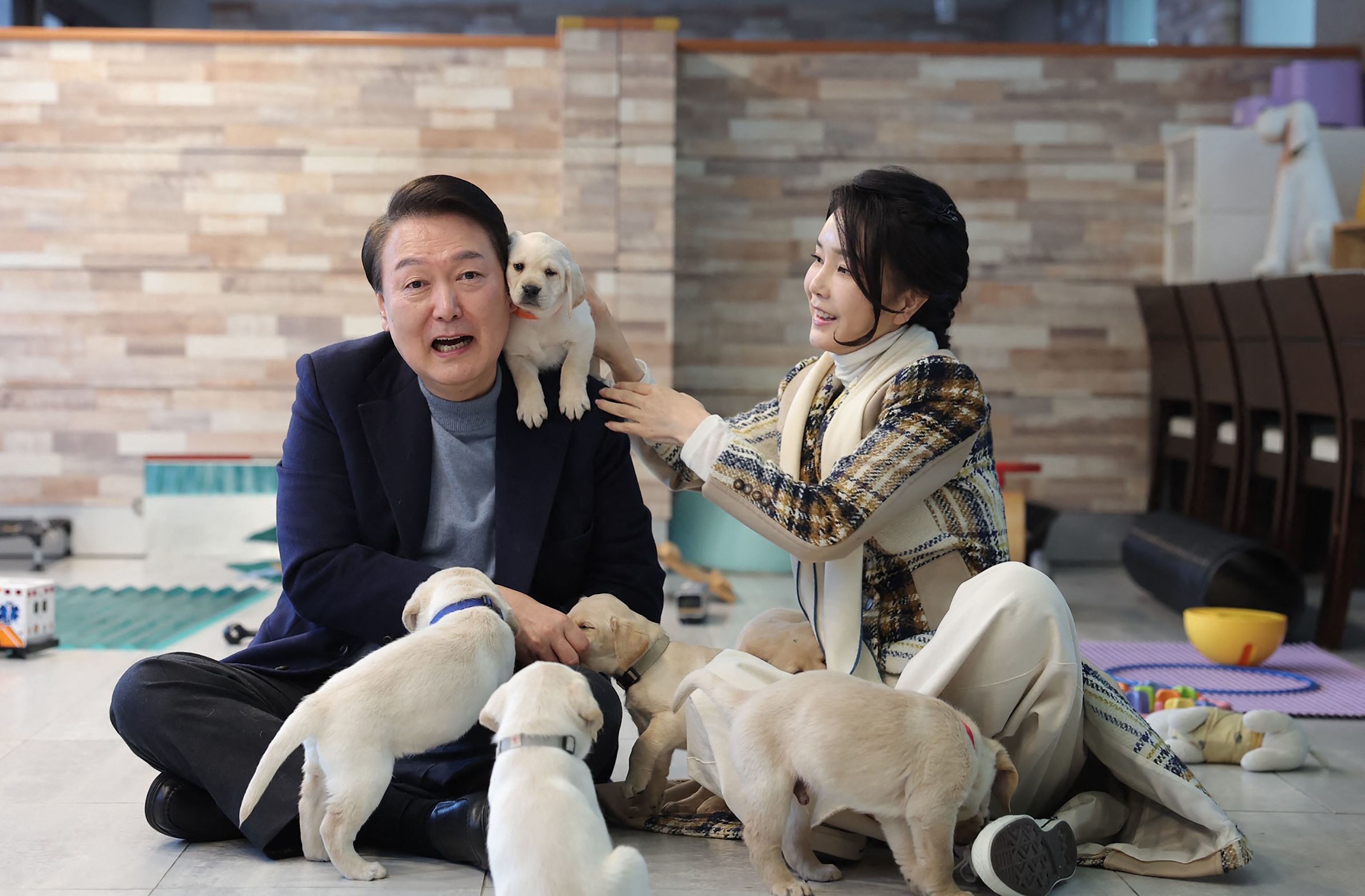 El presidente Yoon Suk Yeol y su mujer posan con cachorros.