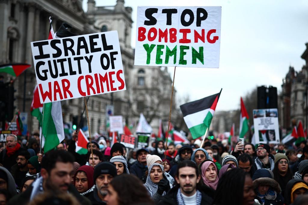 Dos pancartas durante la manifestacin en Londres: una denuncia crmenes de guerra por parte de Israel y la otra pide el cese de bombardeos en Yemen.