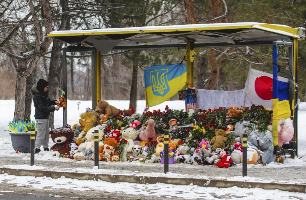 Homenaje con flores en una parada de autobs cerca de las ruinas de un edificio residencial destruido en un ataque con misiles el 14 de enero de 2023 en el que murieron 46 personas.