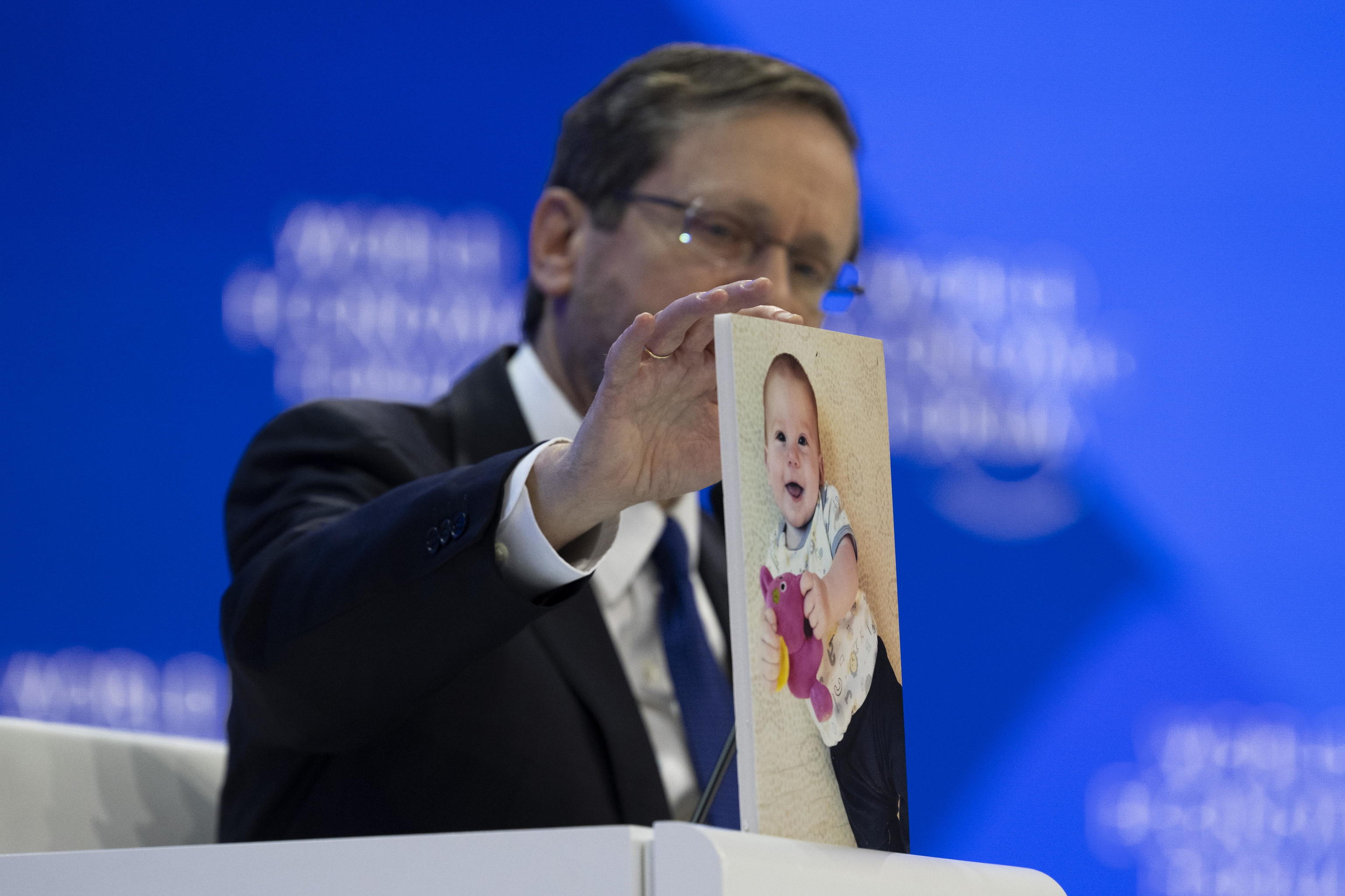 El presidente de Israel, Isaac Herzog, mostrando al auditorio la foto de un beb secuestrado por Hamas.