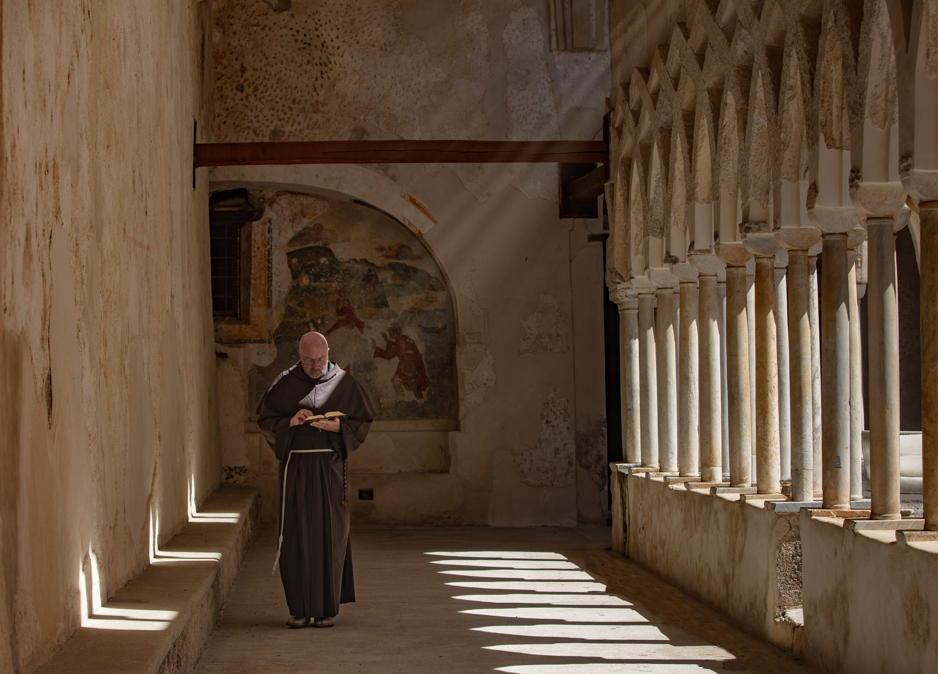 Un monje camina por el claustro.