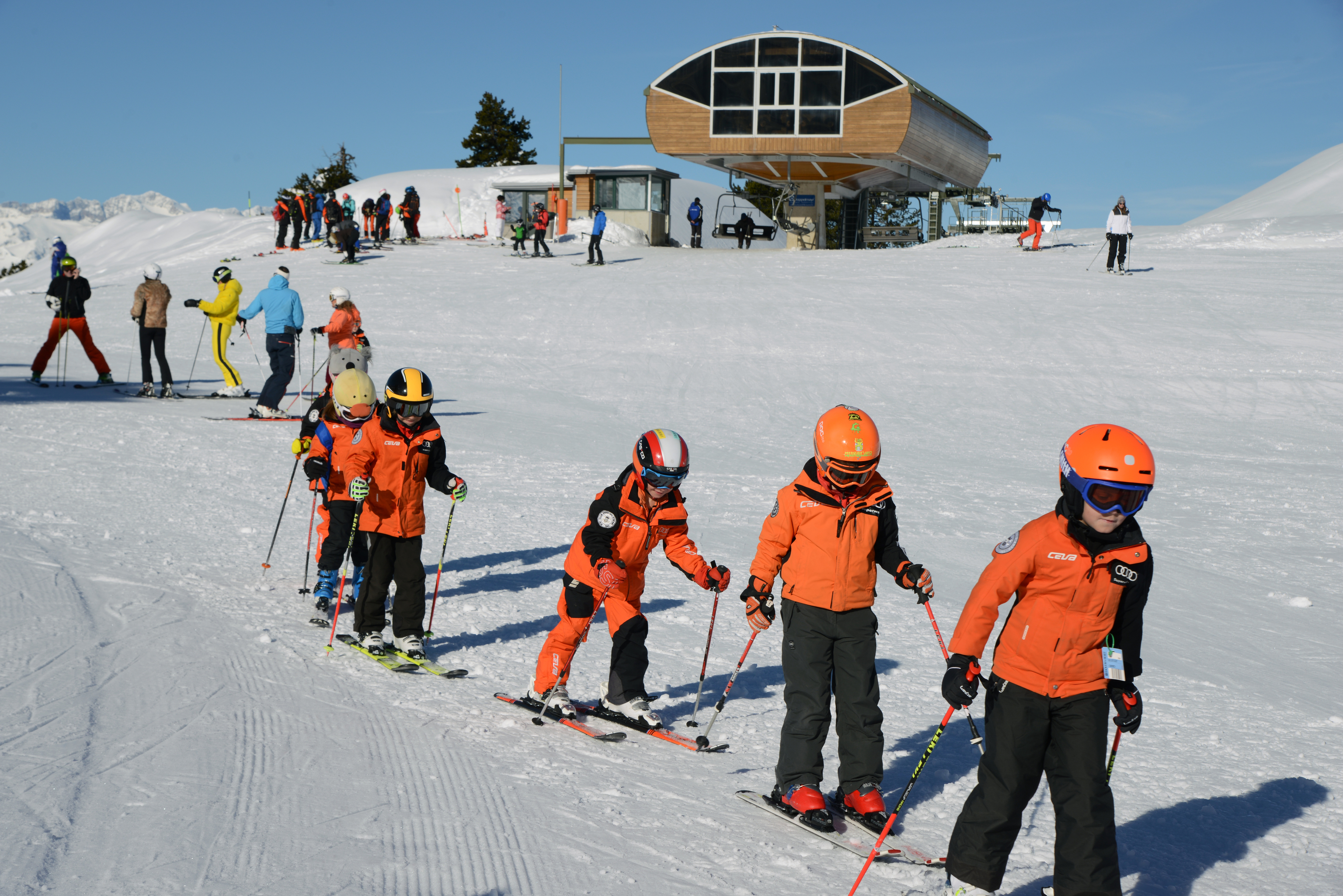 Varios pequeños disfrutan de una clase de esquí infantil.