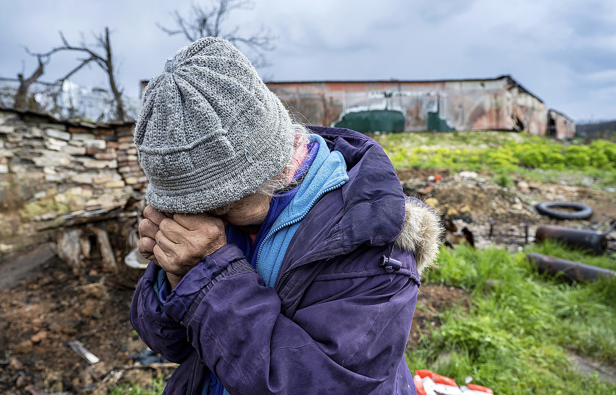 Una mujer ucraniana llora junto a su casa destruida.