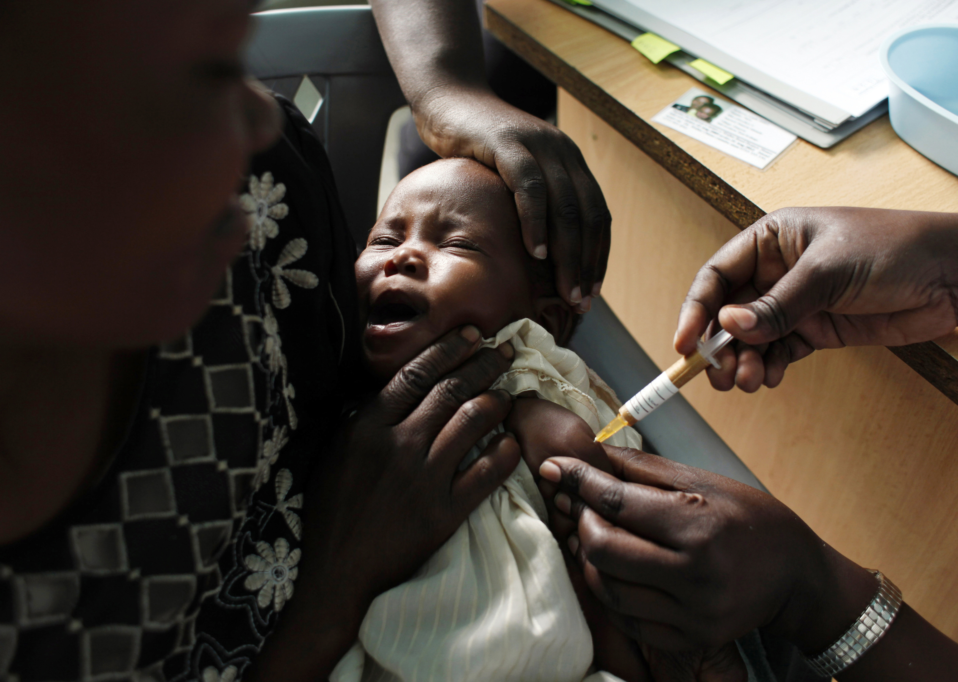 Una madre sostiene a su bebé que recibe una nueva vacuna contra la malaria como parte de un ensayo en Kombewa, en el oeste de Kenia.