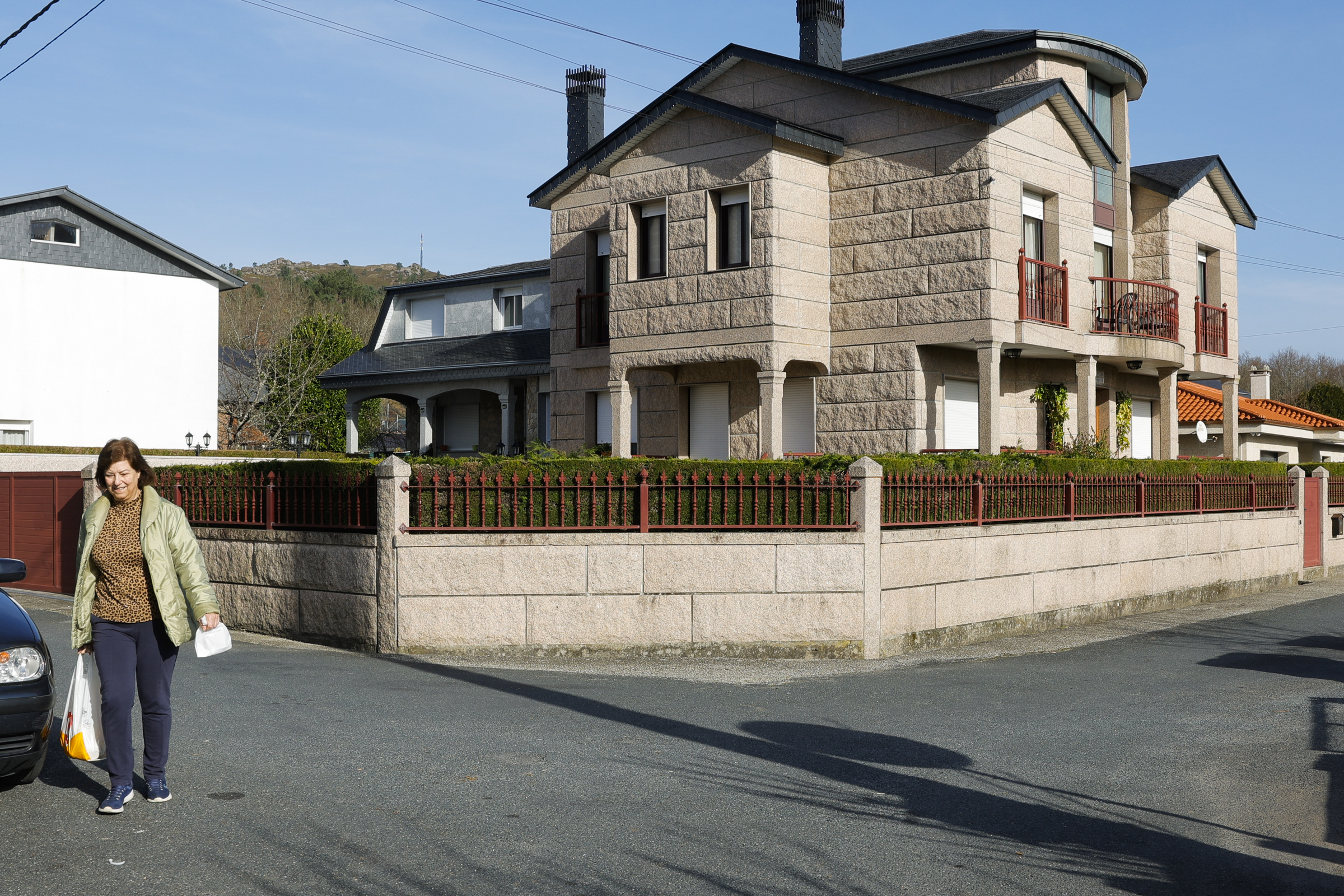 Una vecina camina por Avin frente a una de las mansiones.