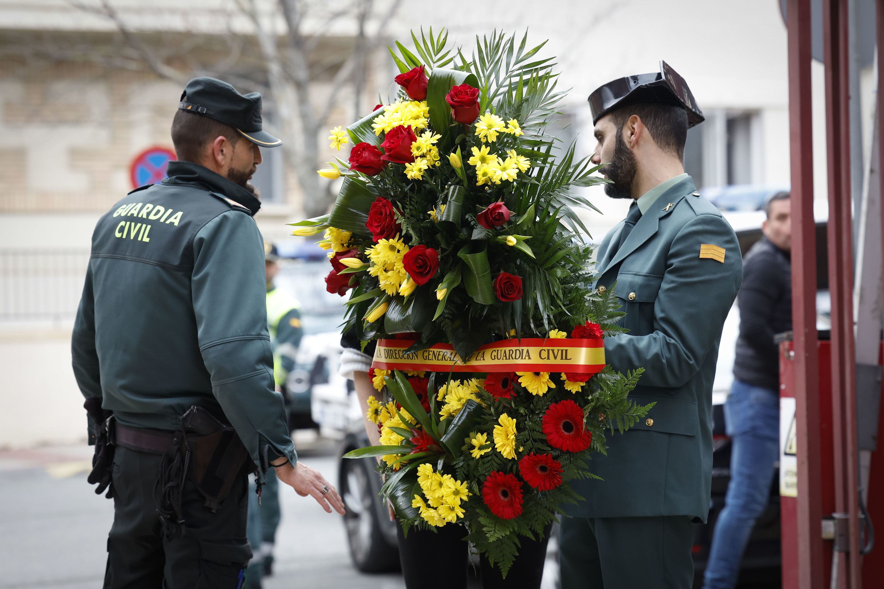 Unos agentes portan un ramo de flores en la comandancia de la Guardia Civil de Pamplona.