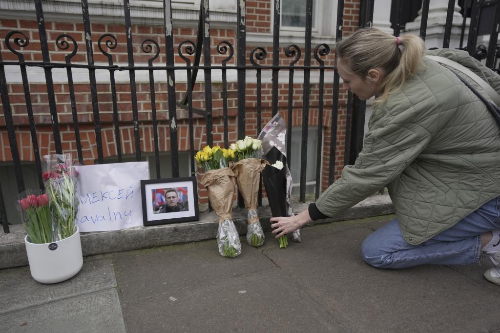 Una mujer deposita flores por Navalny frente a la embajada de Rusia en Londres.