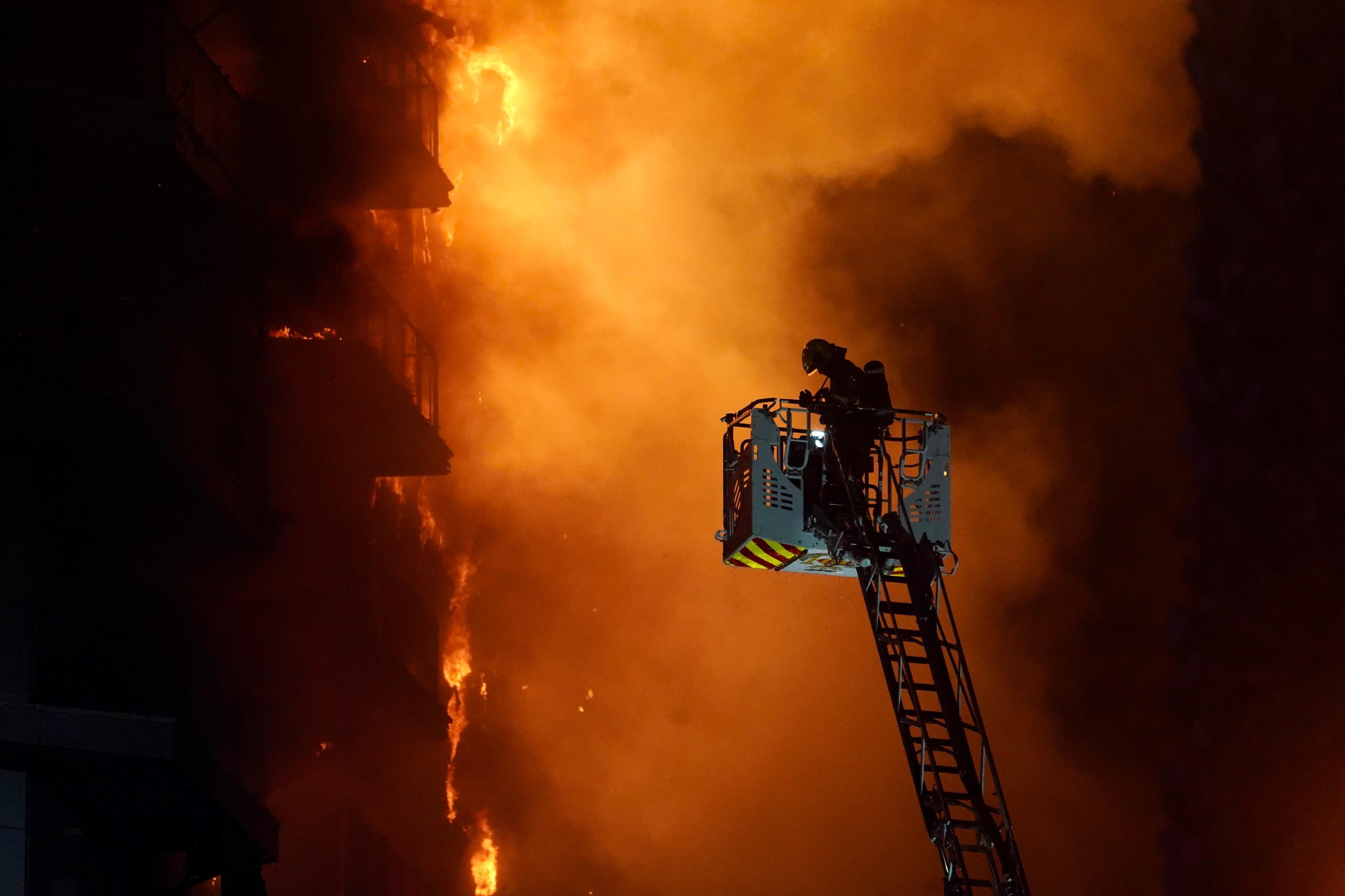 Un bombero trata de apagar el edificio en llamas en Valencia.