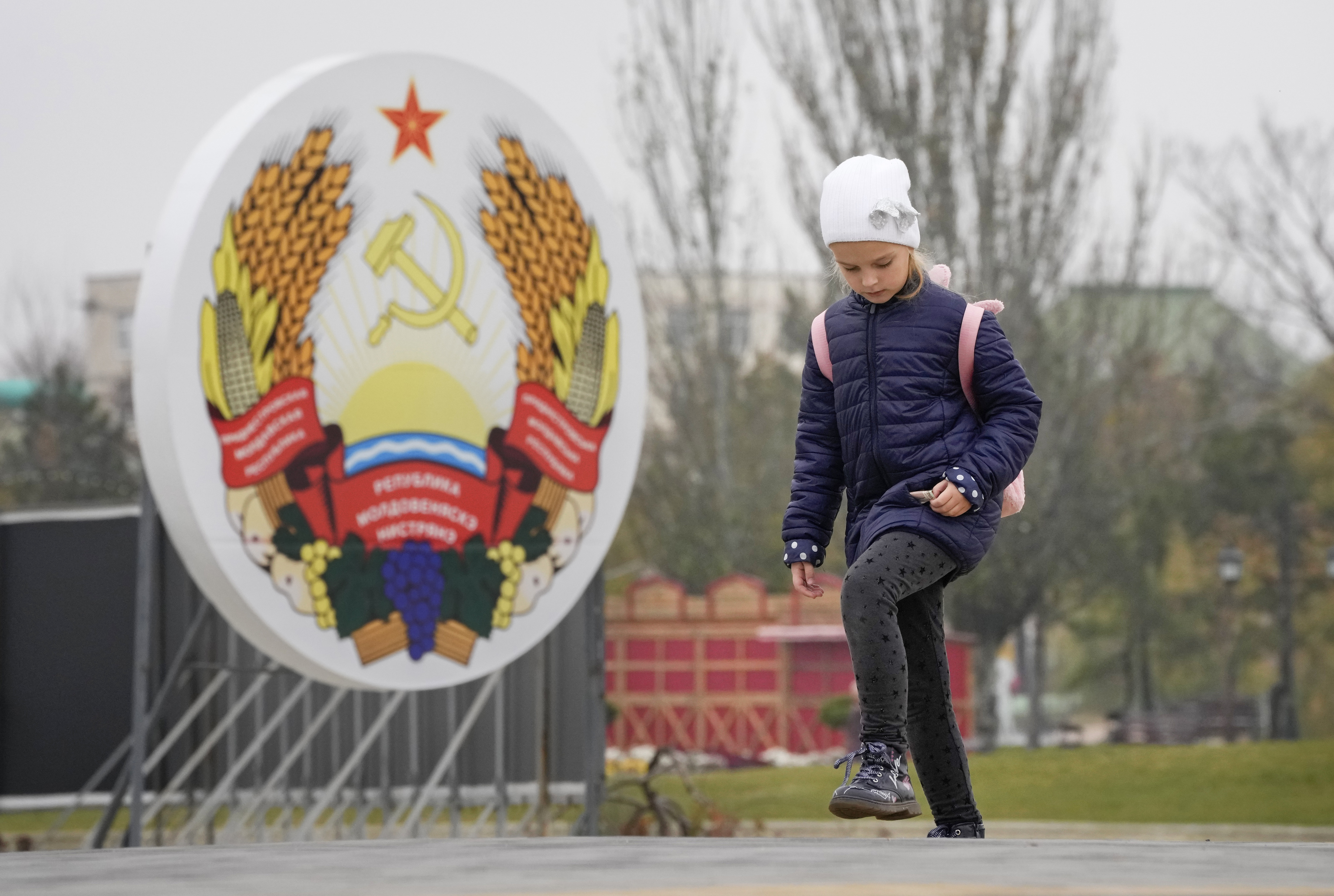 Una nia pasa frente el escudo de armas de Transnistria, en Tirspol, capital de la regin separatista prorrusa de Moldavia.