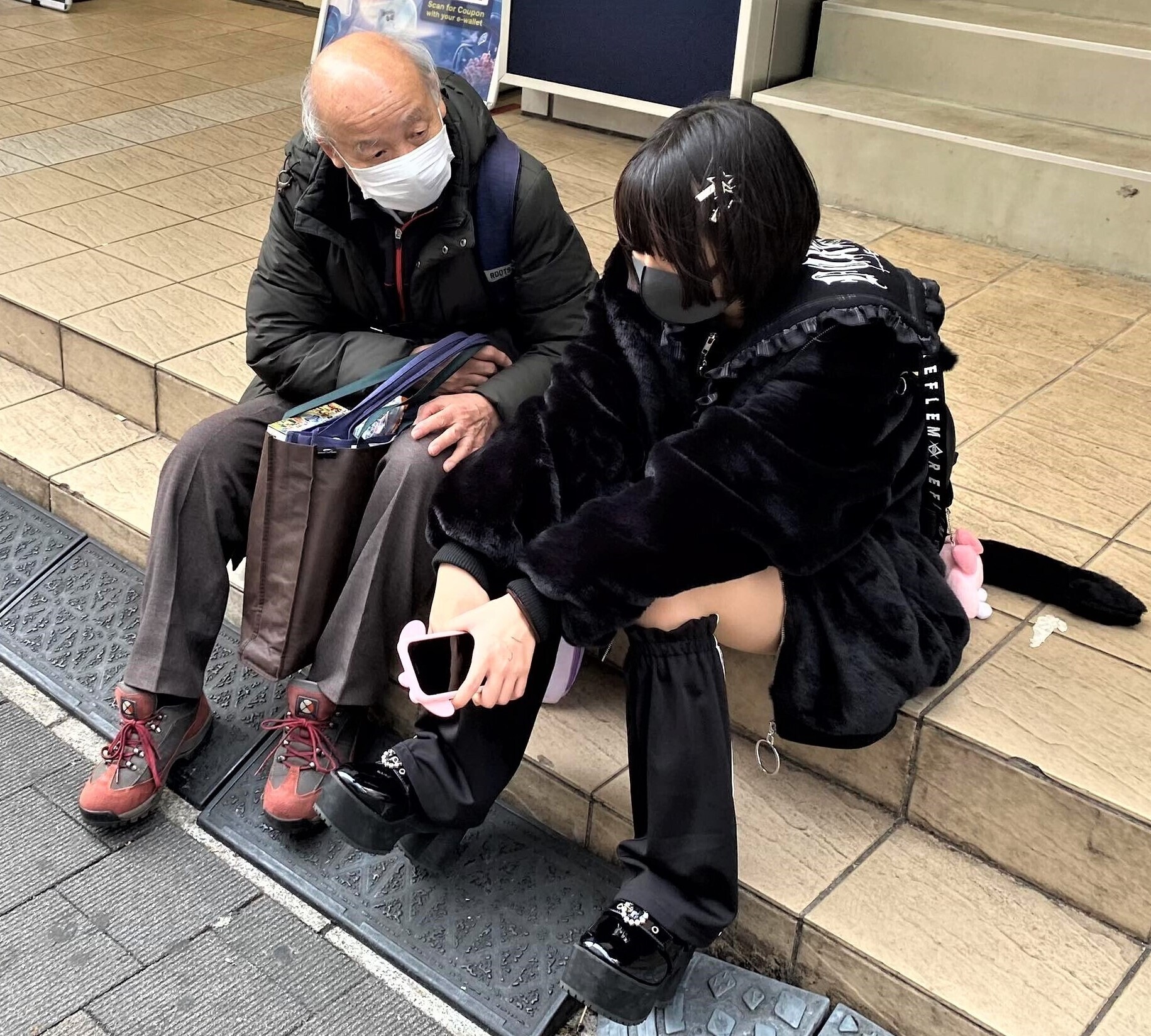Un seor mayor se sienta junto a una menor en Tokio.