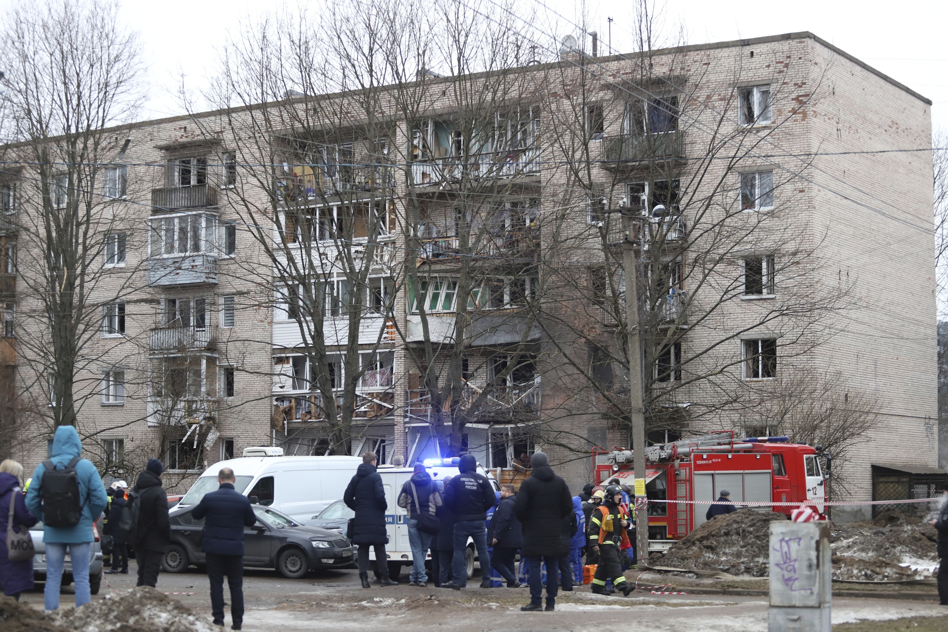Efectivos de emergencia trabajan en el lado del edificio del apartamento dañado.