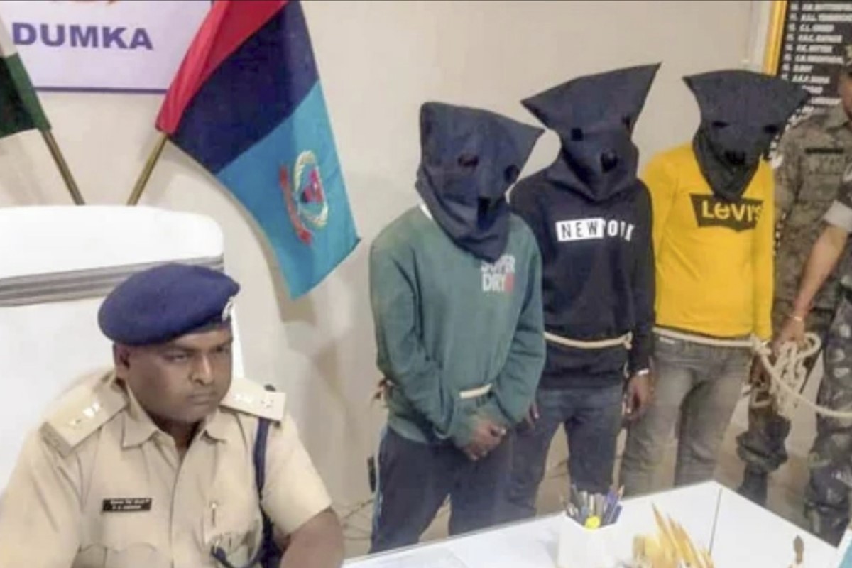 Tres de los ocho violadores detenidos, con capuchas y atados con cuerdas.
