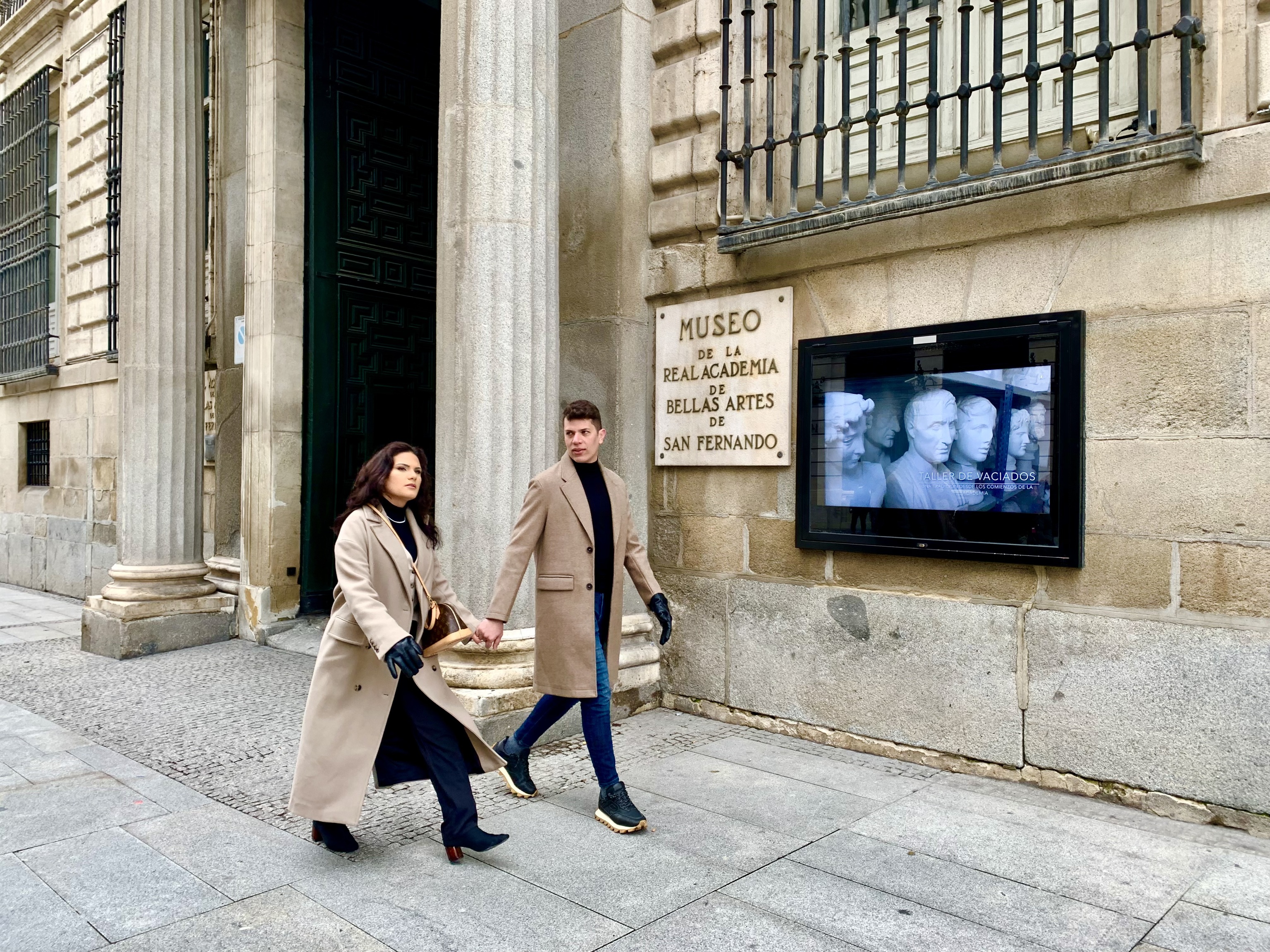Dos personas pasean por la Real Academia de las Bellas Artes.