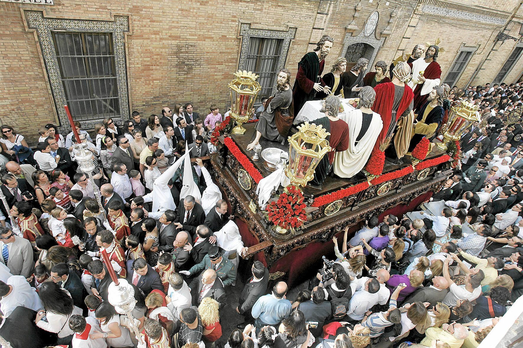 Procesin de El Misterio de La Cena rodeado de gente, durante el Domingo de Ramos de la Semana Santa de Sevilla.