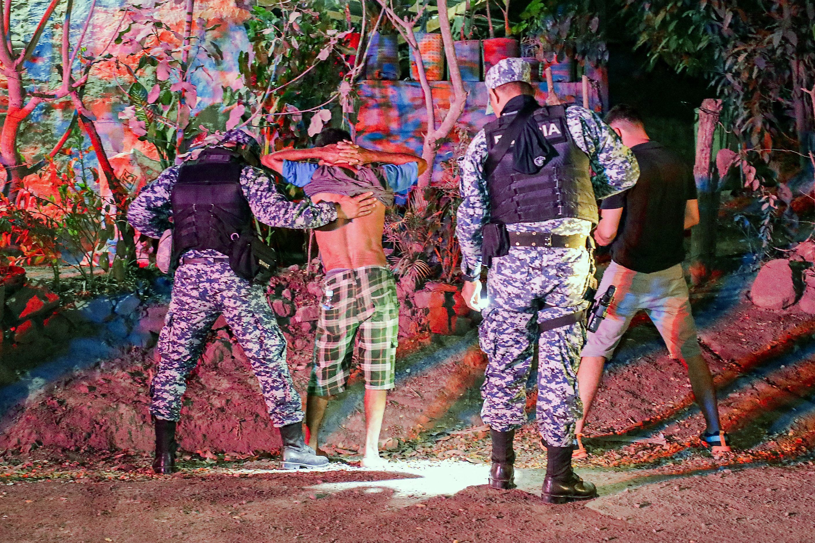 Imagen proporcionada el 25 de marzo de 2024 por la oficina de prensa de la presidencia de El Salvador que muestra a fuerzas de seguridad registrando a dos sospechosos durante una operacin para rodear a los restos de pandillas despus de las muertes de dos personas en el sur de Chalatenango, al norte de El Salvador, el 24 de marzo de 2024. El gobierno de Nayib Bukele despleg 6.000 militares y policas para rodear los distritos de San Jos Cancasque, San Antonio Los Ranchos, Potonico y San Isidro Labrador, con el fin de desmantelar por completo la pandilla 18S, presuntamente responsable de los dos asesinatos. (Foto de Handout / OFICINA DE PRENSA DE LA PRESIDENCIA DE EL SALVADOR / AFP)