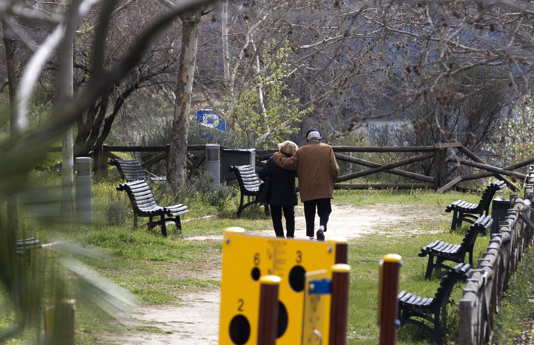 Una pareja de ancianos pasea por un parque.