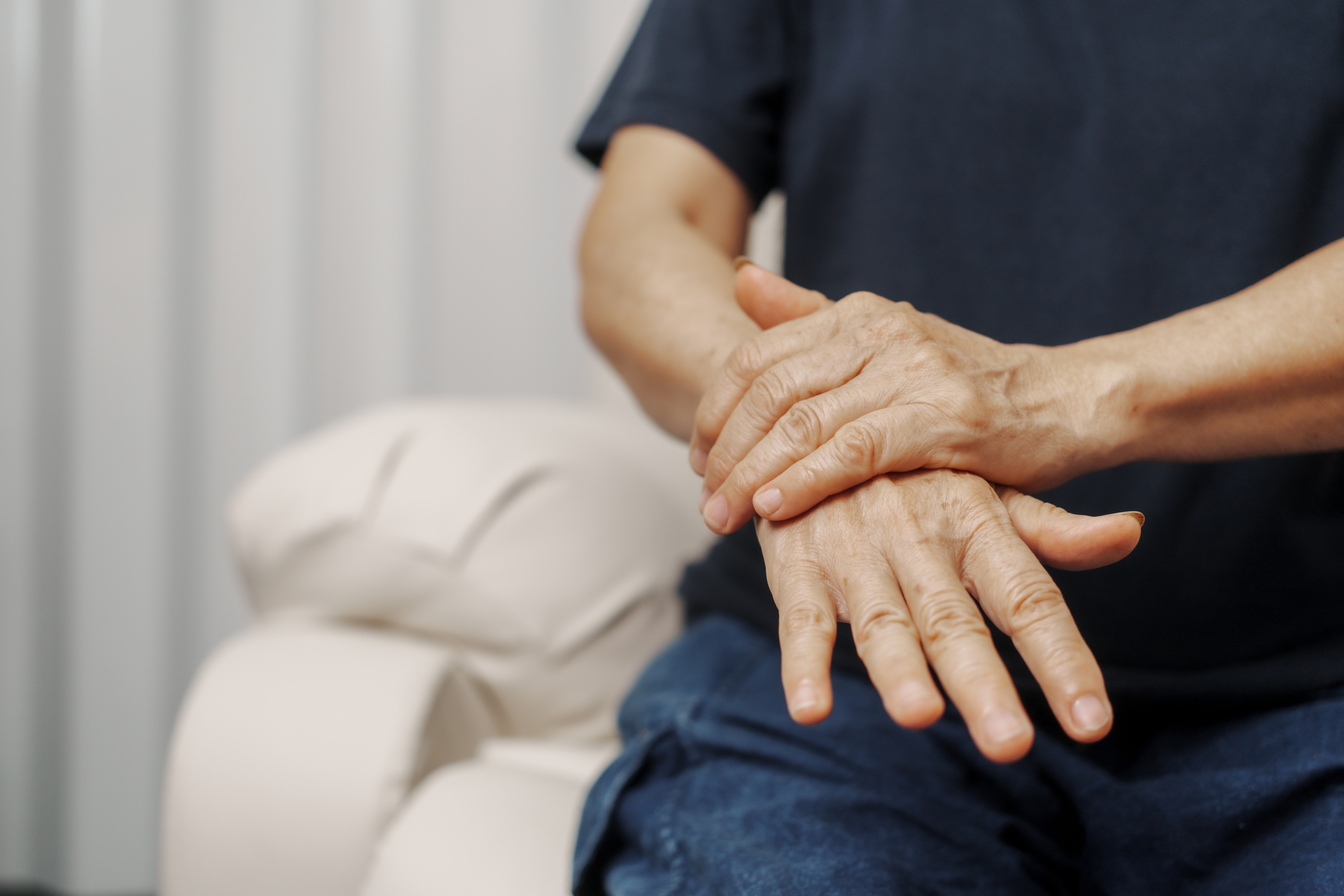 Una paciente muestra sus manos con entumecimiento y bloqueo de los dedos.