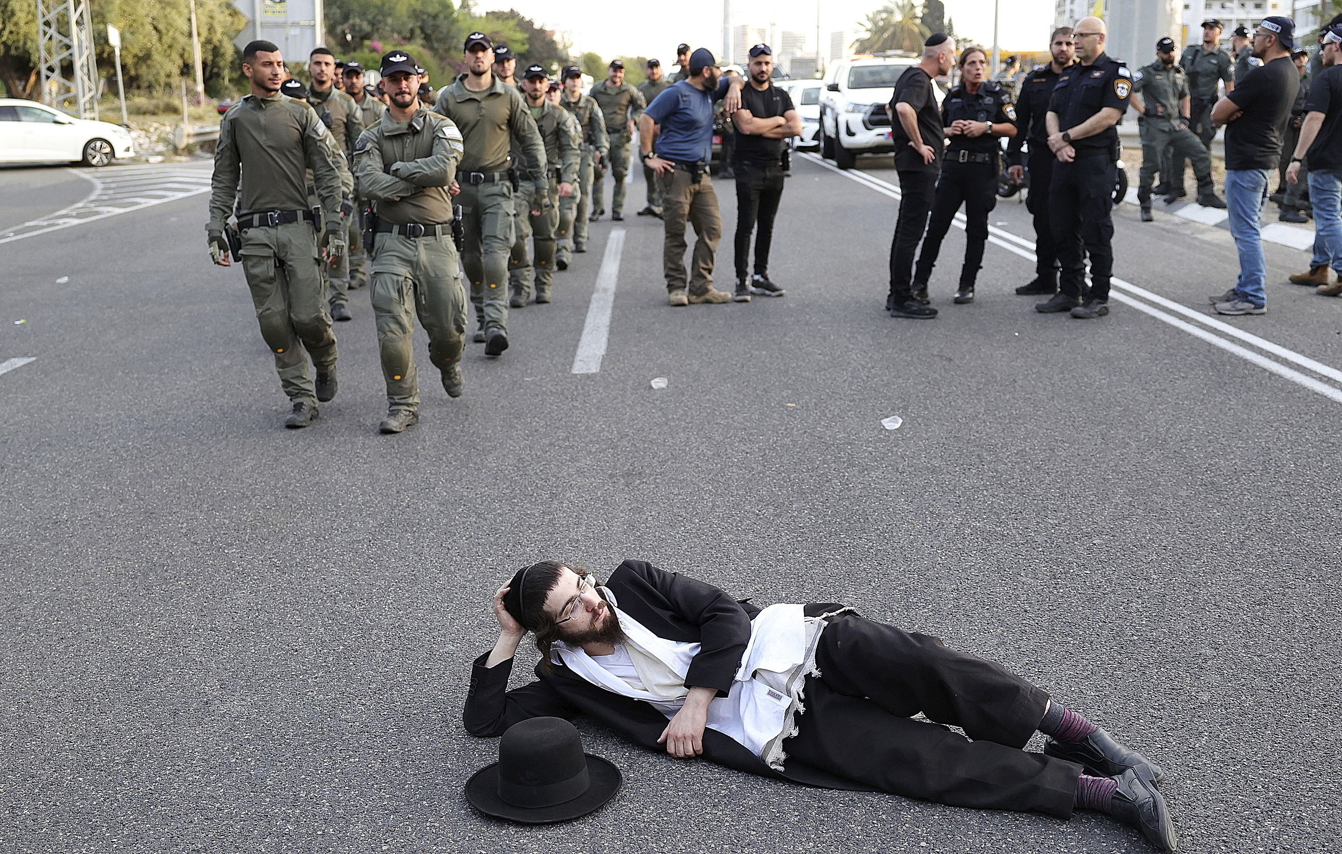 Un joven bloquea una carretera en una protesta contra el reclutamiento de ultraortodoxos.