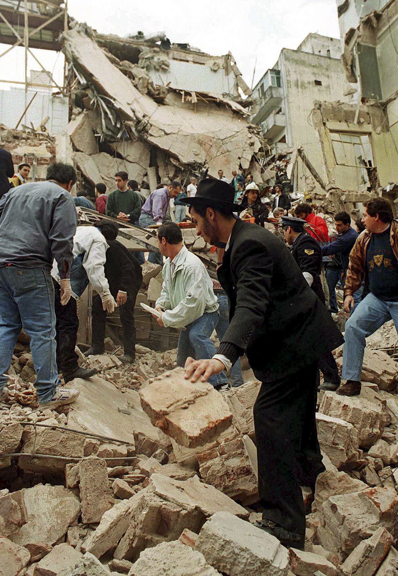 Varias personas buscan supervivientes entre los escombros de la sede de la AMIA en Argentina, el 18 de julio de 1994.