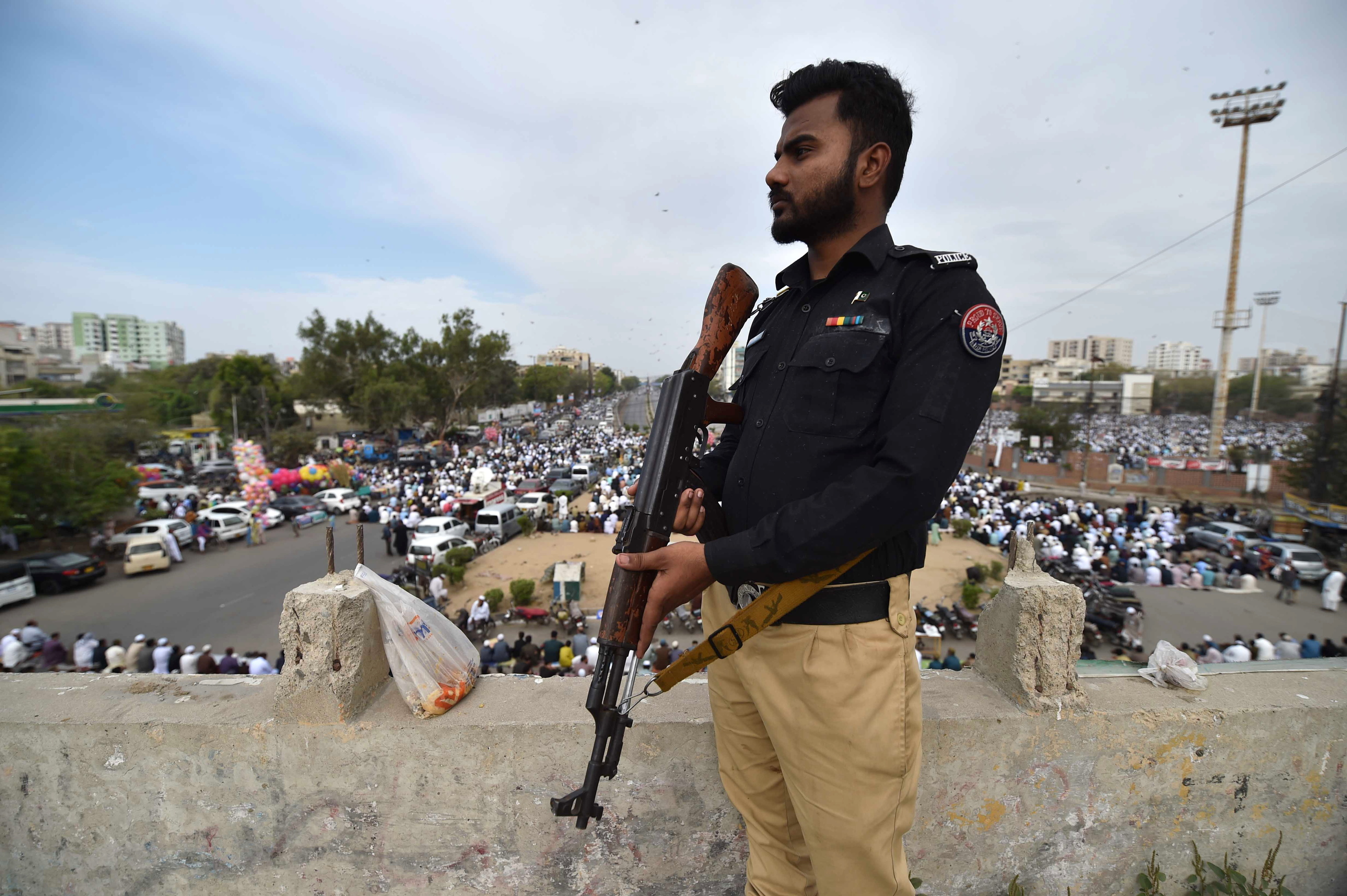 Un agente de polica monta guardia mientras musulmanes paquistanes realizan la oracin del Eid al-Fitr en Karachi, Pakistn, el 10 de abril de 2024. Los musulmanes de todo el mundo celebran el Eid al-Fitr, una festividad de dos o tres das, al final del mes sagrado musulmn de ayuno del Ramadn. Es una de las dos principales festividades del Islam. Durante el Eid al-Fitr, la mayora de la gente viaja para visitarse en la ciudad o fuera de ella y los nios reciben ropa nueva y dinero para gastar en la ocasin