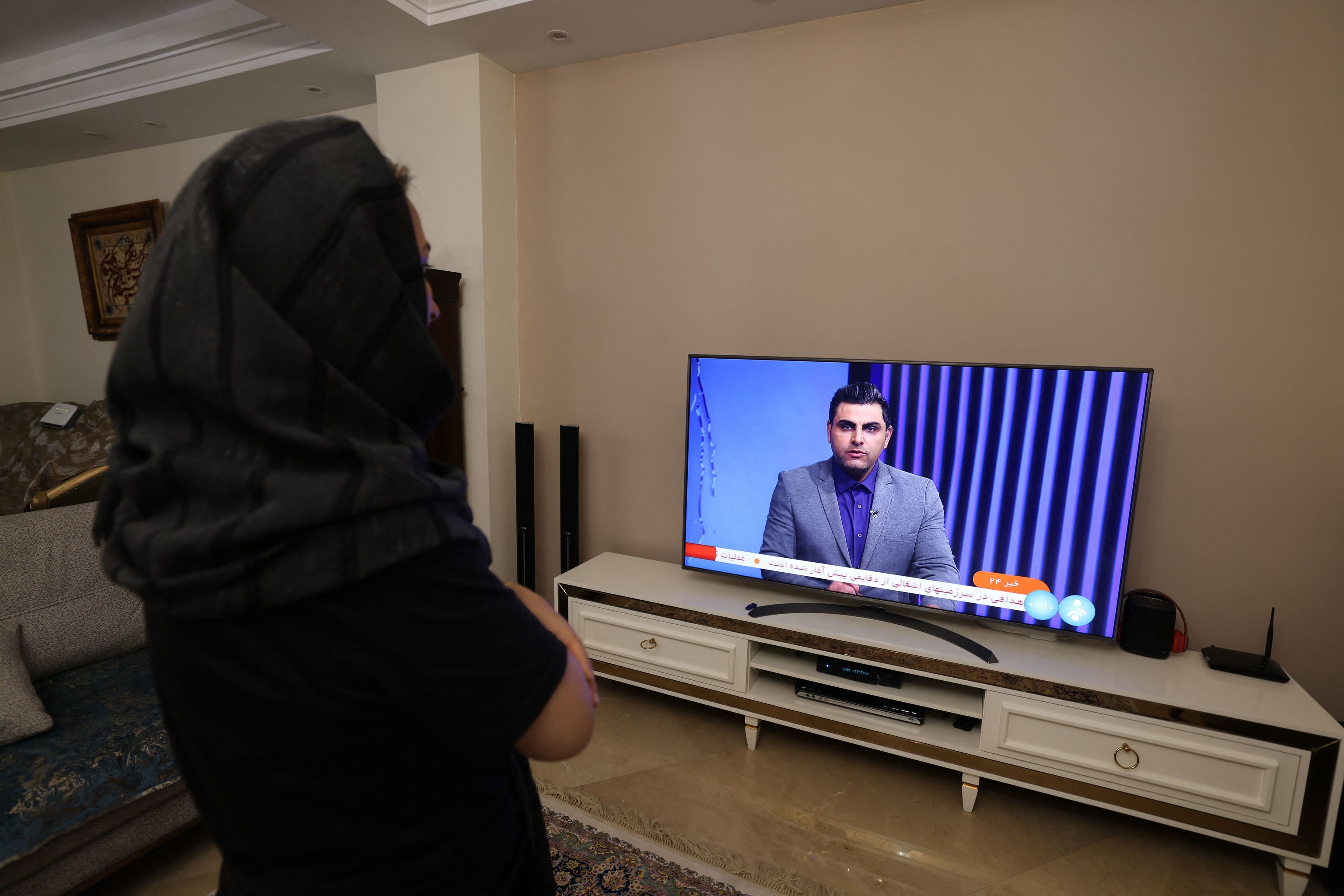 Una mujer en Irn sigue en televisin las noticias sobre el ataque a Israel.