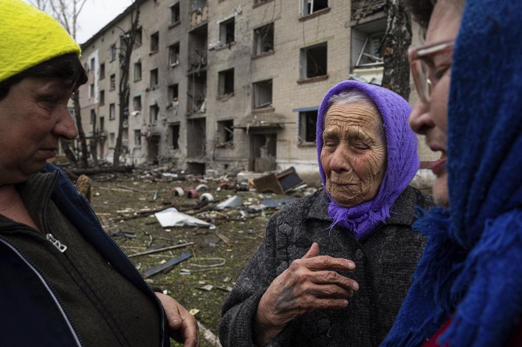 Olga, de 79 aos, en el centro, llora mientras se despide de sus vecinos frente a su casa, daada por un ataque areo ruso, en Lukiantsi (Jrkov).